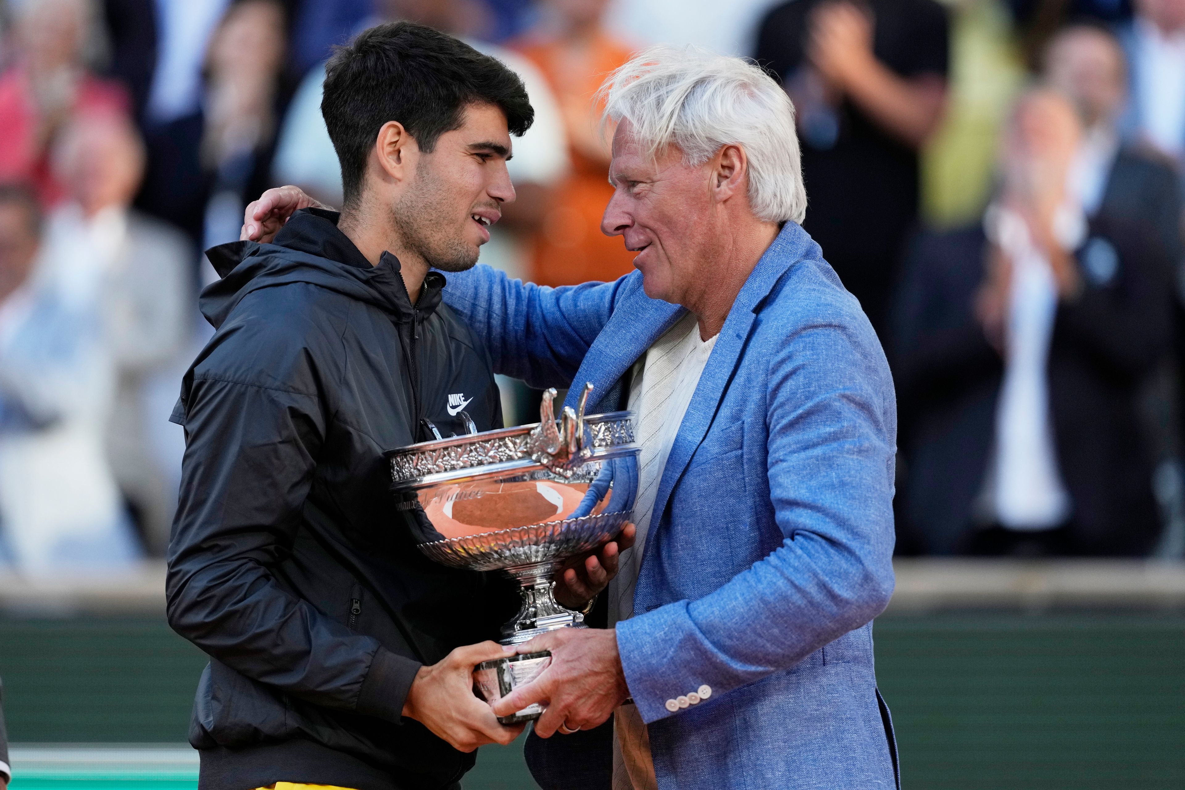 Winner Spain's Carlos Alcaraz, left, hugs with tennis star Bjorn Borg as he celebrates with the trophy after the men's final match of the French Open tennis tournament against Germany's Alexander Zverev at the Roland Garros stadium in Paris, Sunday, June 9, 2024.