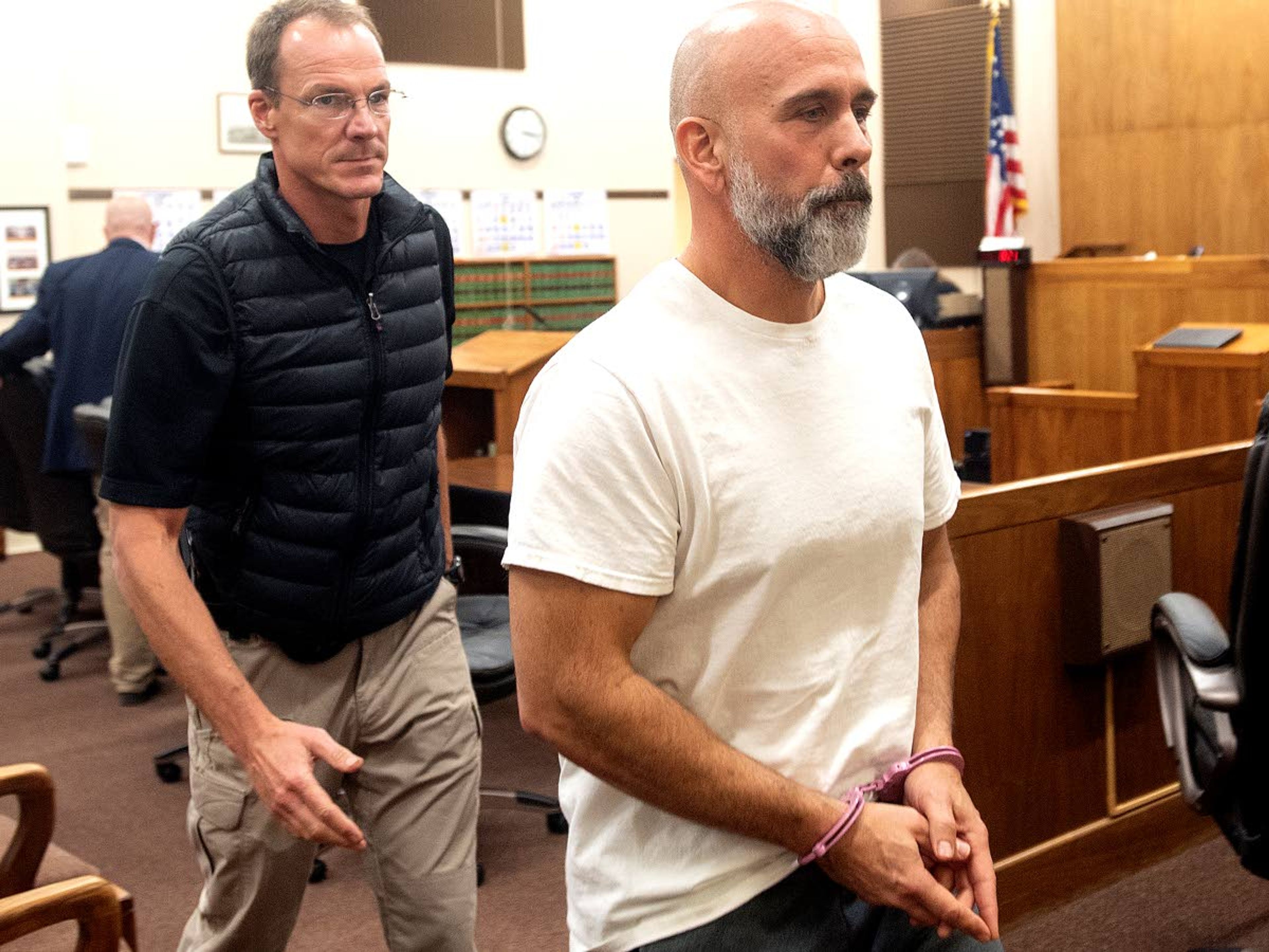 Pullman Police Department Sgt. Dan Hargraves (right) is escorted out of a Whitman County Superior Court room after his arraignment hearing Tuesday afternoon in Colfax.