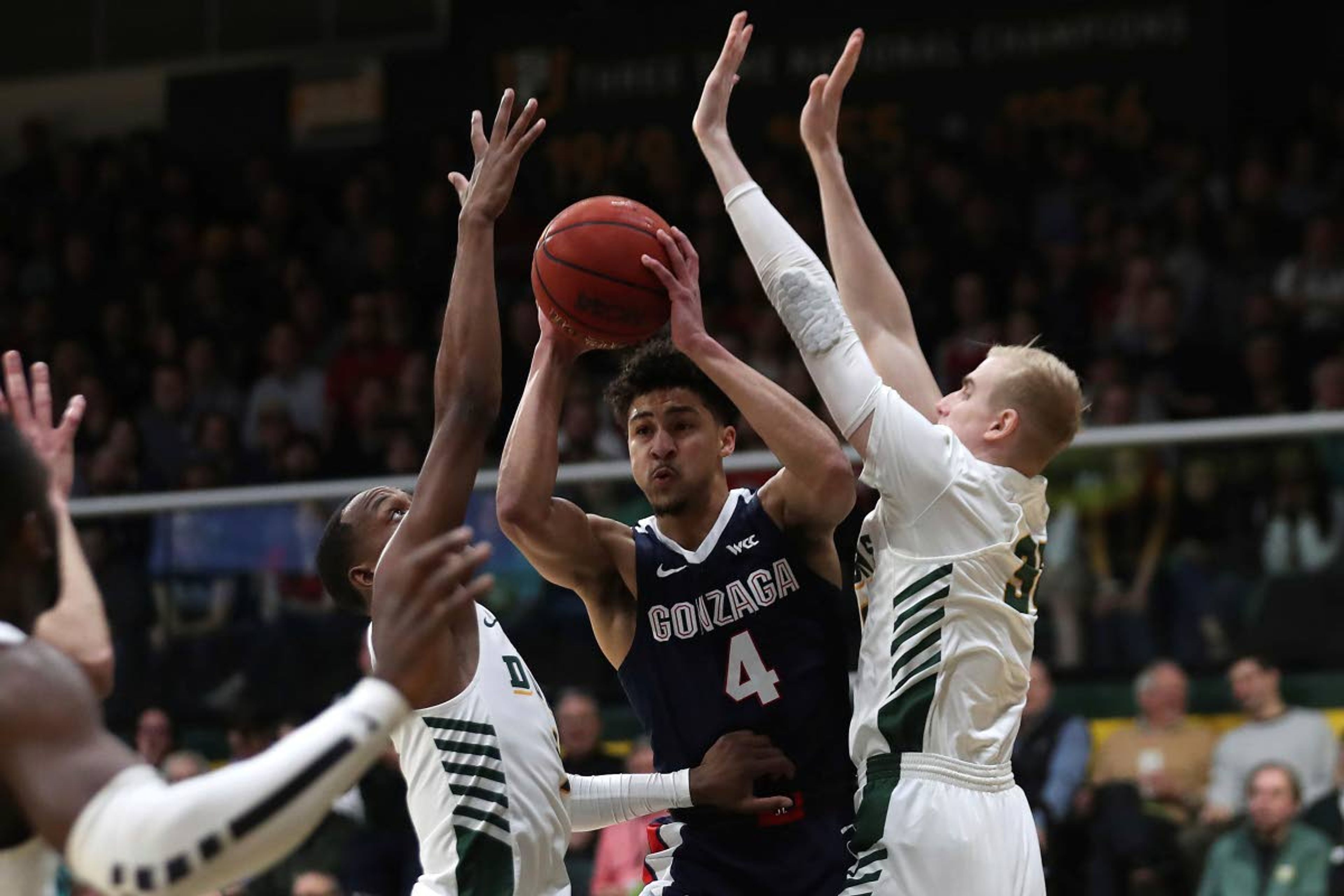 Gonzaga guard Ryan Woolridge (4) is defended by San Francisco center Jonas Visser (31) and Khalil Shabazz (1) during the first half of an NCAA college basketball game in San Francisco, Saturday, Feb. 1, 2020. (AP Photo/Jed Jacobsohn)