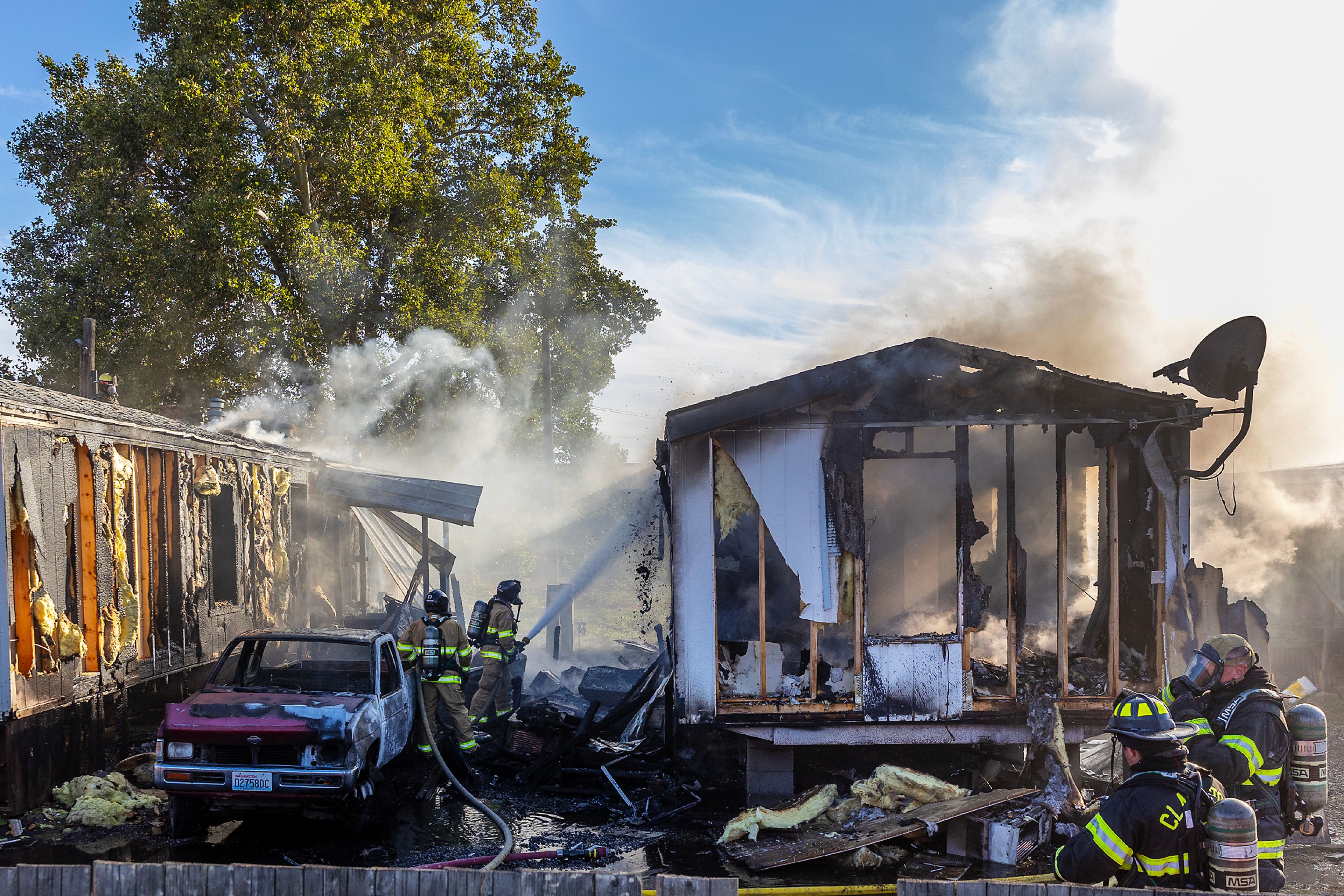 Firefighters work to put out a fire at two mobile homes Thursday off 13th Street in Clarkston.