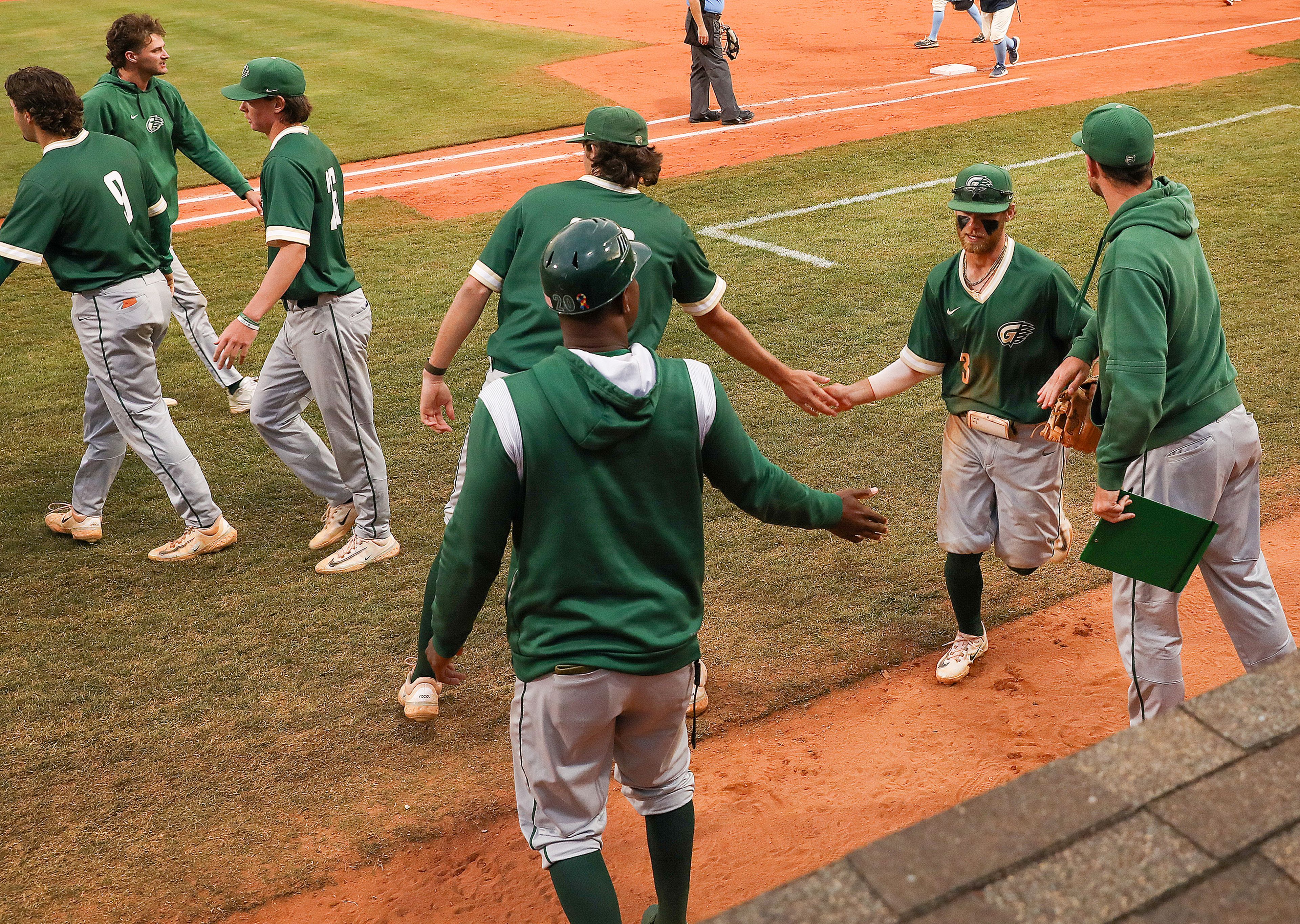 Georgia Gwinnett players high-five as they run in from the field during a game against Reinhardt in Game 14 of the NAIA World Series at Harris Field Tuesday in Lewiston.