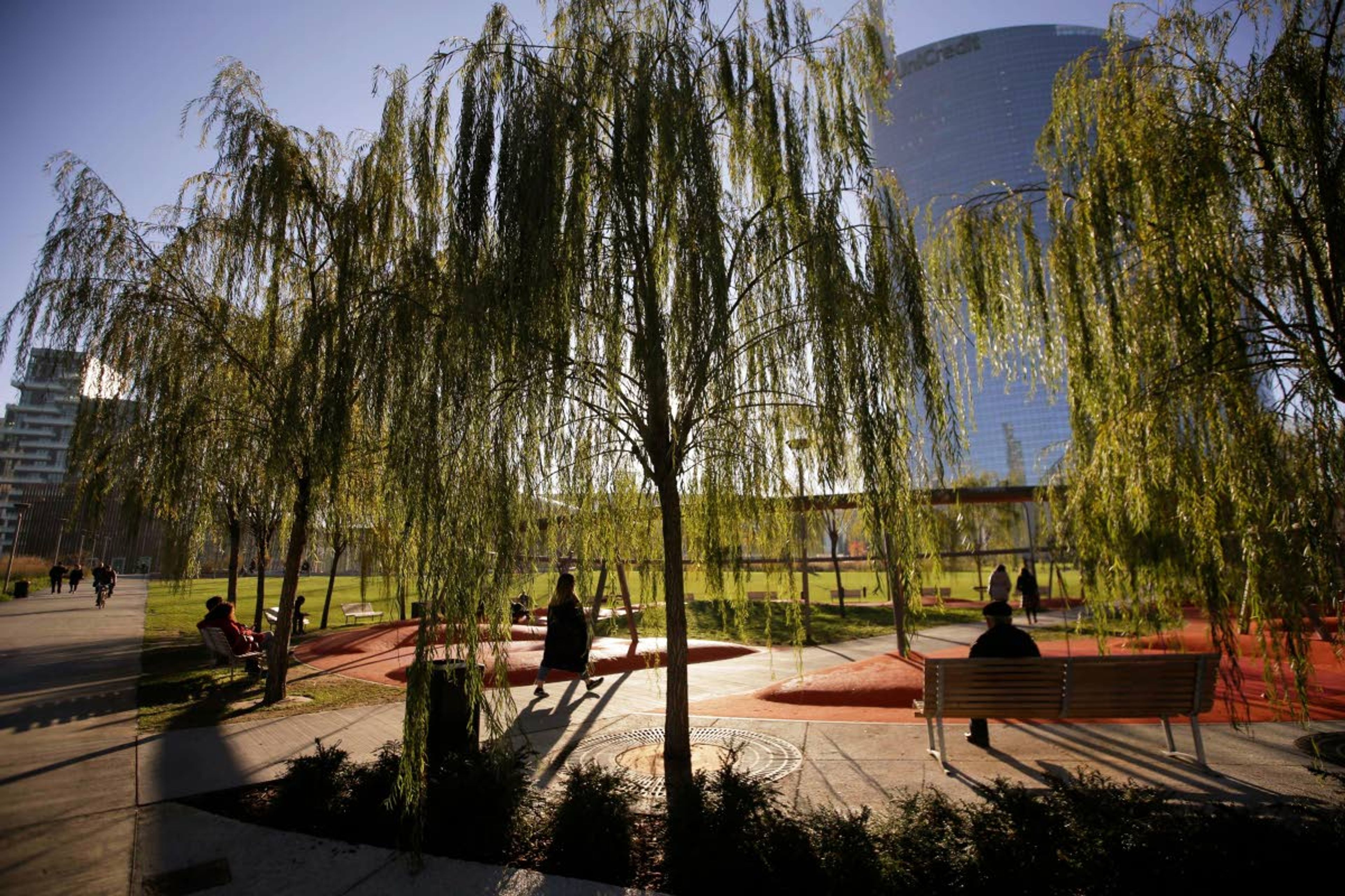 FILE - In this Dec. 4, 2018 file photo, people walk in Tree Library park in Milan, Italy. The city has ambitious plans to plant 3 million new trees by 2030_ a move that experts say could offer relief to the city's muggy and sometimes tropical weather. A study released on Thursday, July 4, 2019 says that the most effective way to fight global warming is to plant lots of trees - a trillion of them, maybe more. (AP Photo/Luca Bruno)