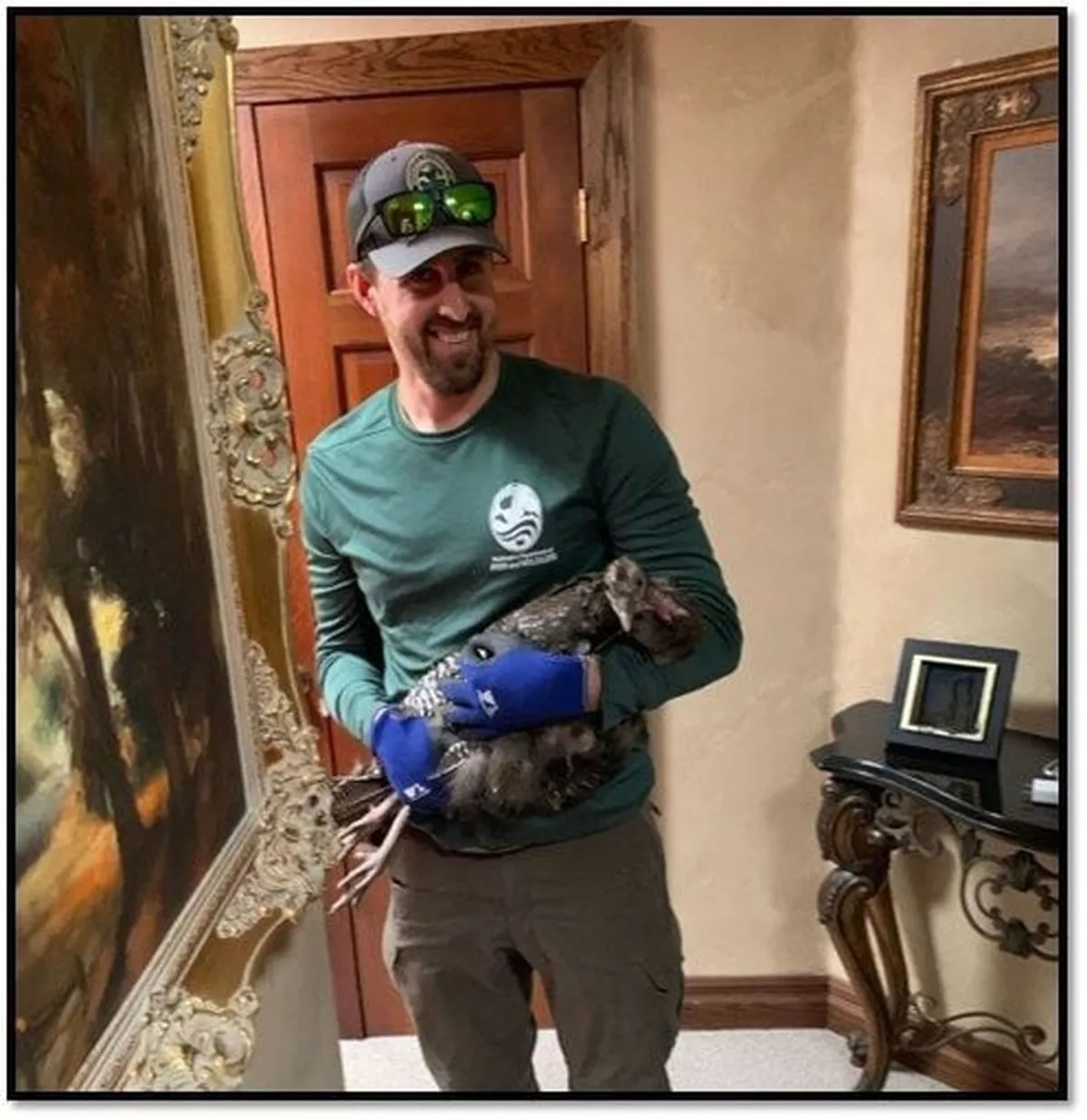 Matt Brinkman, a biologist with the Washington Department of Fish and Wildlife, cradles a turkey in the hallway of a Spokane home it broke into in July.