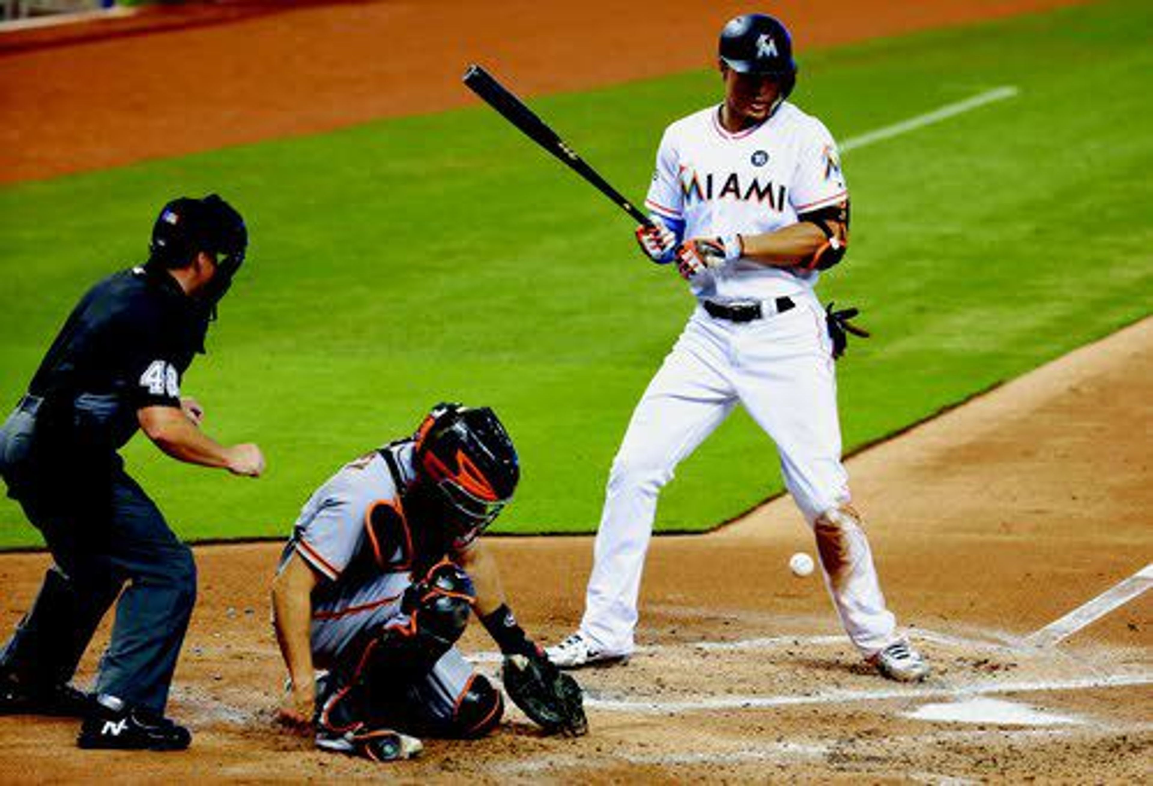 Miami Marlins' Giancarlo Stanton, right, is hit by a pitch thrown by San Francisco Giants starting pitcher Matt Cain during the second inning of a baseball game, Wednesday, Aug. 16, 2017, in Miami. At left is home plate umpire Nick Mahrley (48) and center, San Francisco Giants catcher Nick Hundley. (AP Photo/Lynne Sladky)