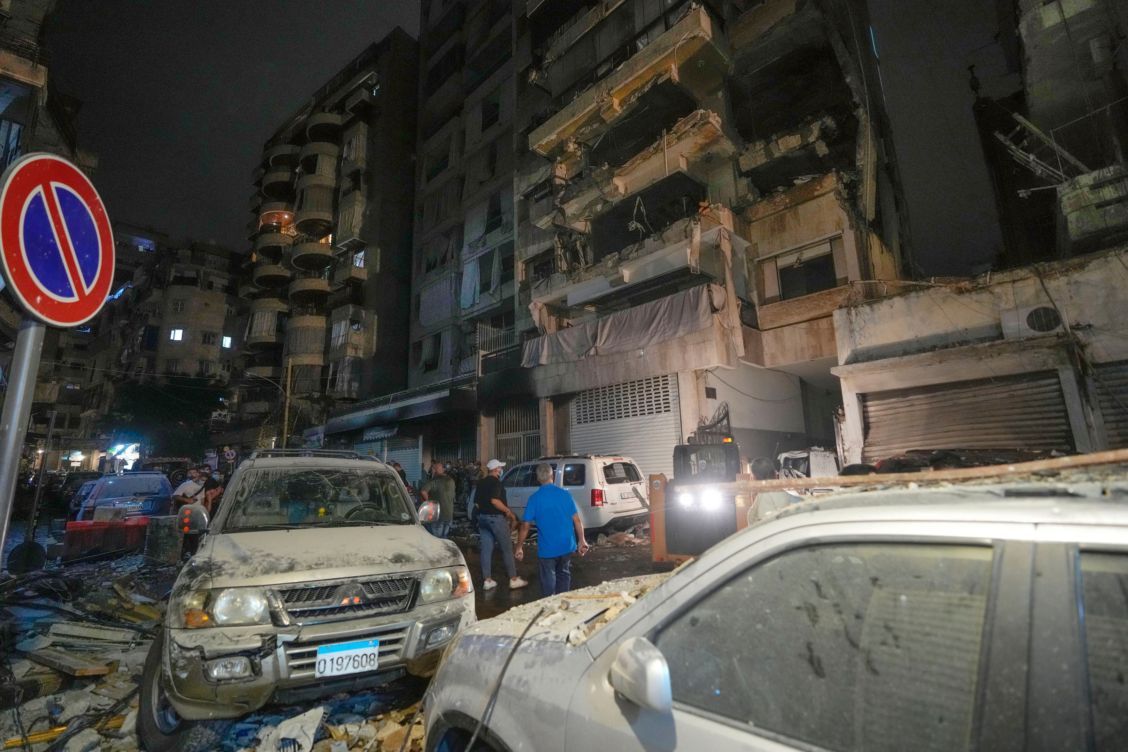 People gather in front of buildings hit by an Israeli airstrike at the site of an Israeli airstrike in Beirut, Lebanon, Thursday, Oct. 10, 2024. (AP Photo/Hassan Ammar)