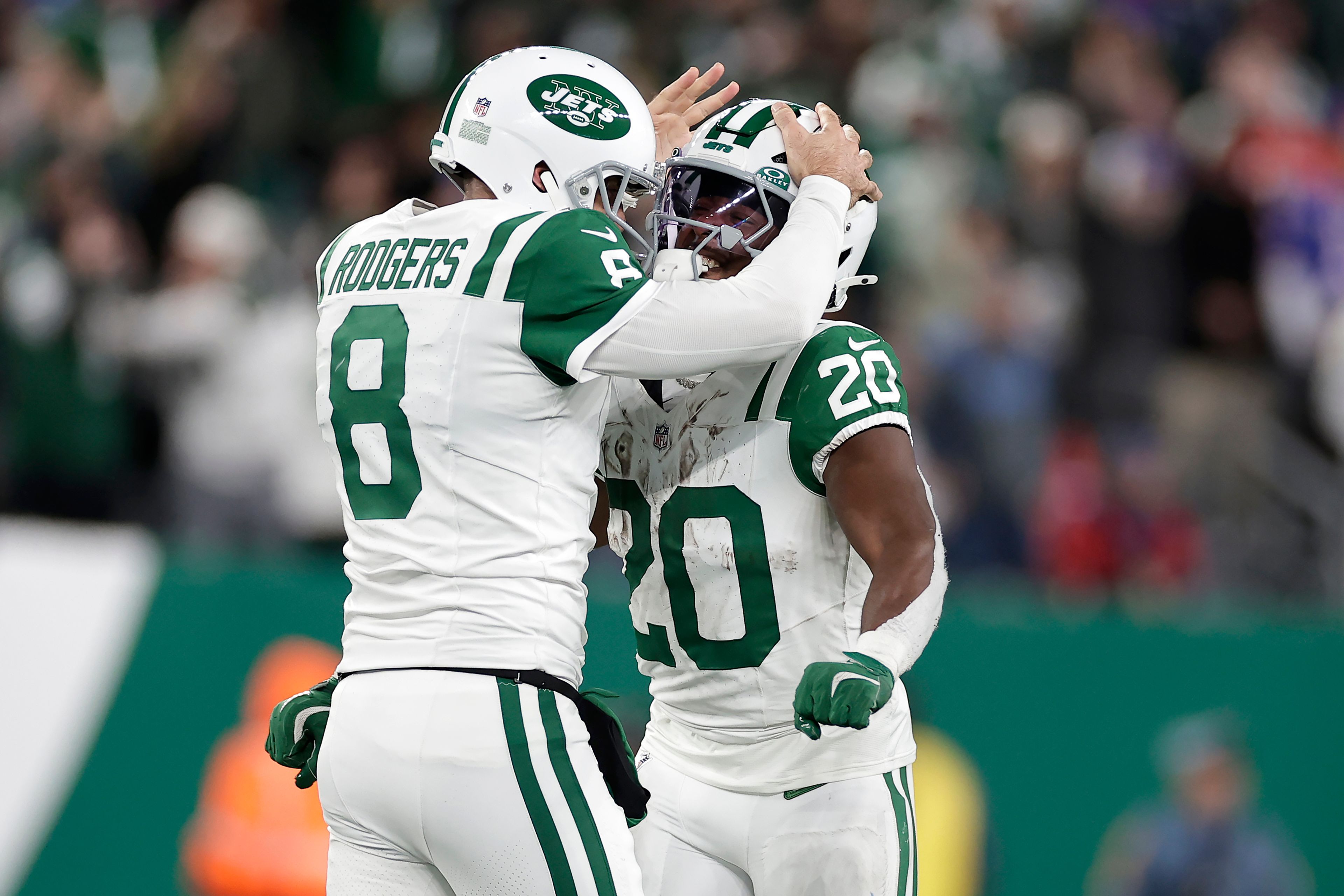 New York Jets quarterback Aaron Rodgers (8) celebrates with running back Frank Gore Jr. (20) after throwing a touchdown pass to wide receiver Allen Lazard during the first half of an NFL football game against the Buffalo Bills in East Rutherford, N.J., Monday, Oct. 14, 2024. (AP Photo/Adam Hunger)