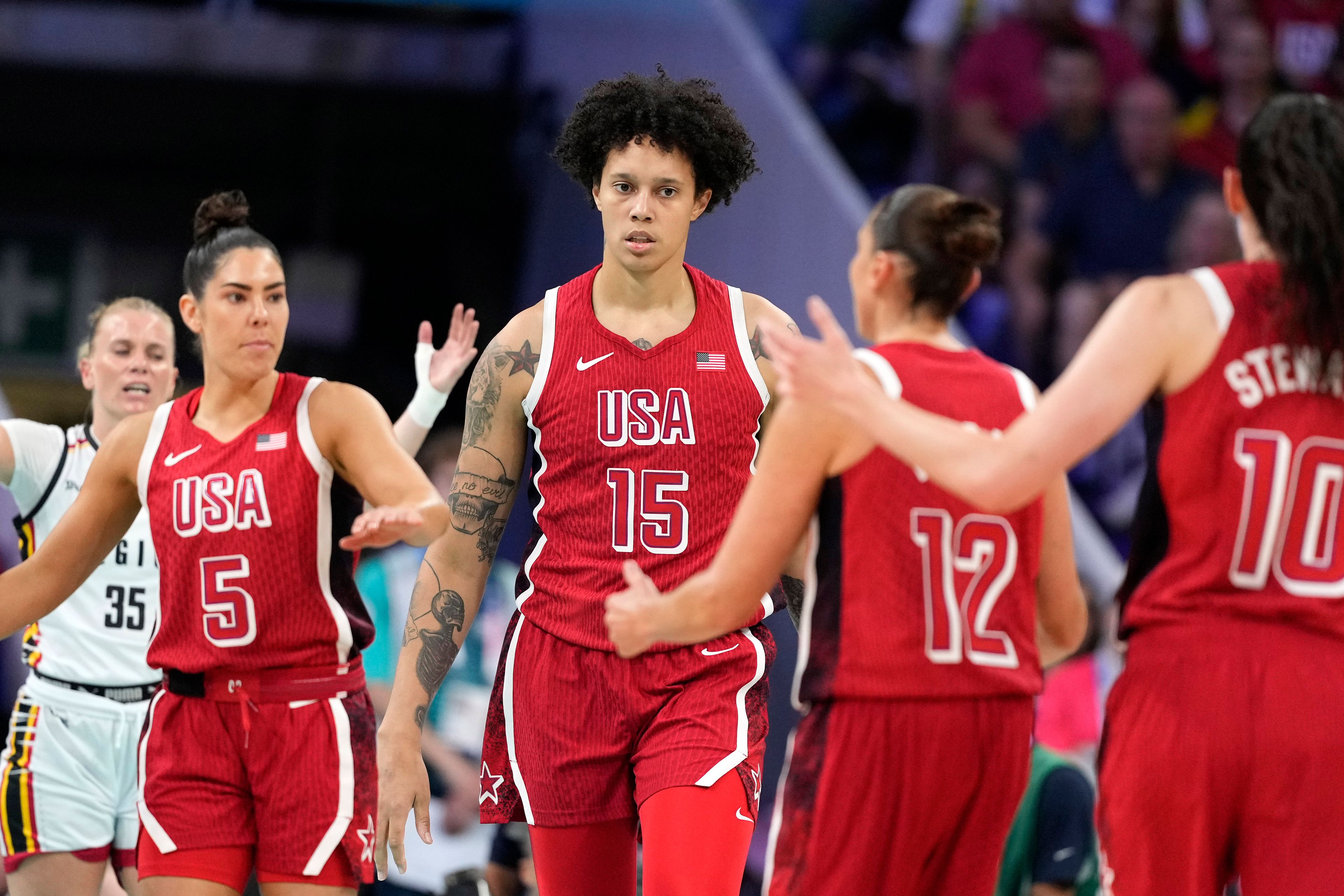 United States' Brittney Griner (15) is surrounded by teammates, United States' Kelsey Plum (5), United States' Diana Taurasi, (12) and United States' Breanna Stewart (10) after being fouled during a women's basketball game against Belgium at the 2024 Summer Olympics, Thursday, Aug. 1, 2024, in Villeneuve-d'Ascq, France. (AP Photo/Michael Conroy)