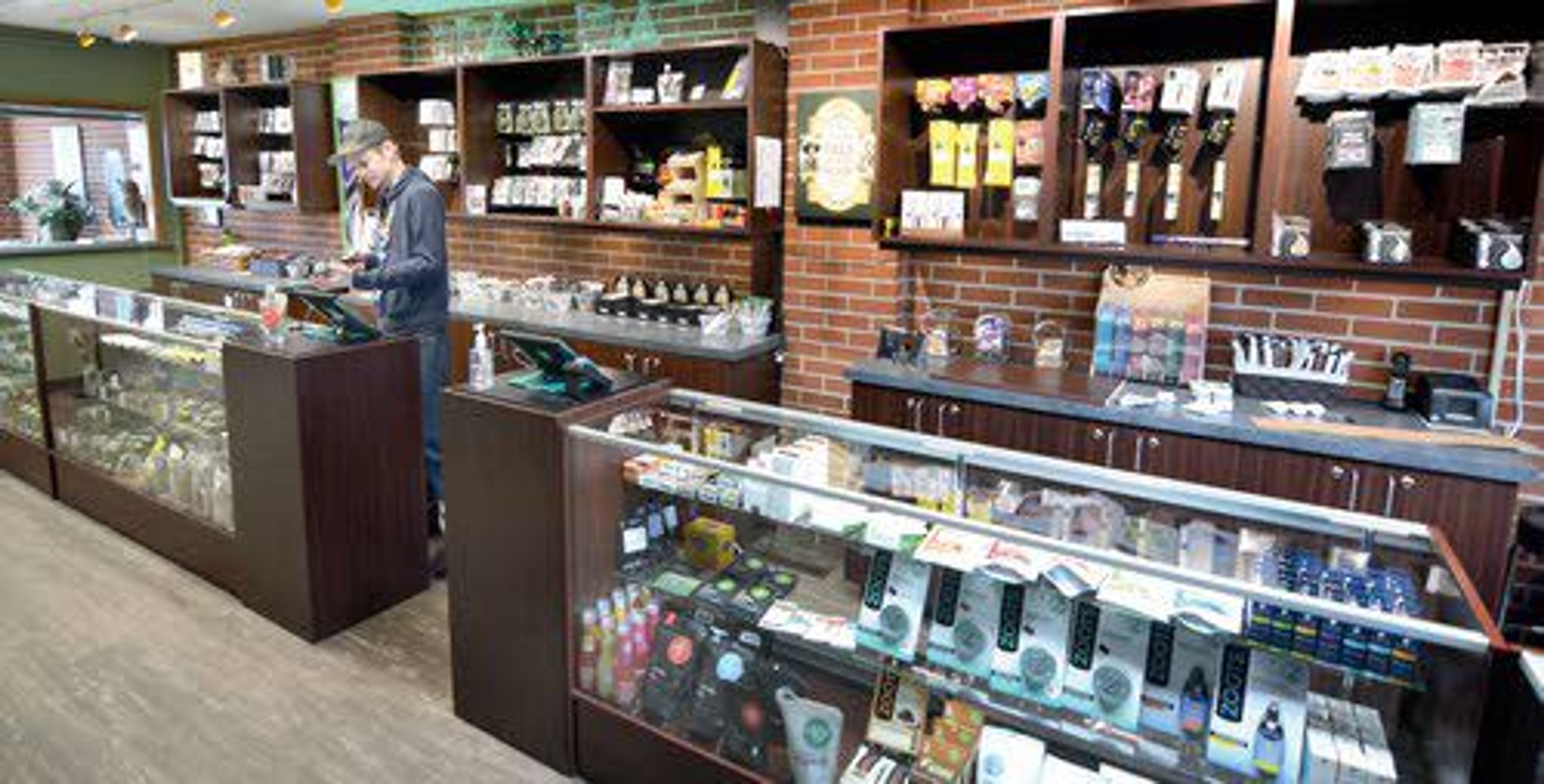 The Greenfield Company store on Clarkston’s Sixth Street is a bright retail outlet where “budtender” David Vache keeps the inventory of cannabis products organized.