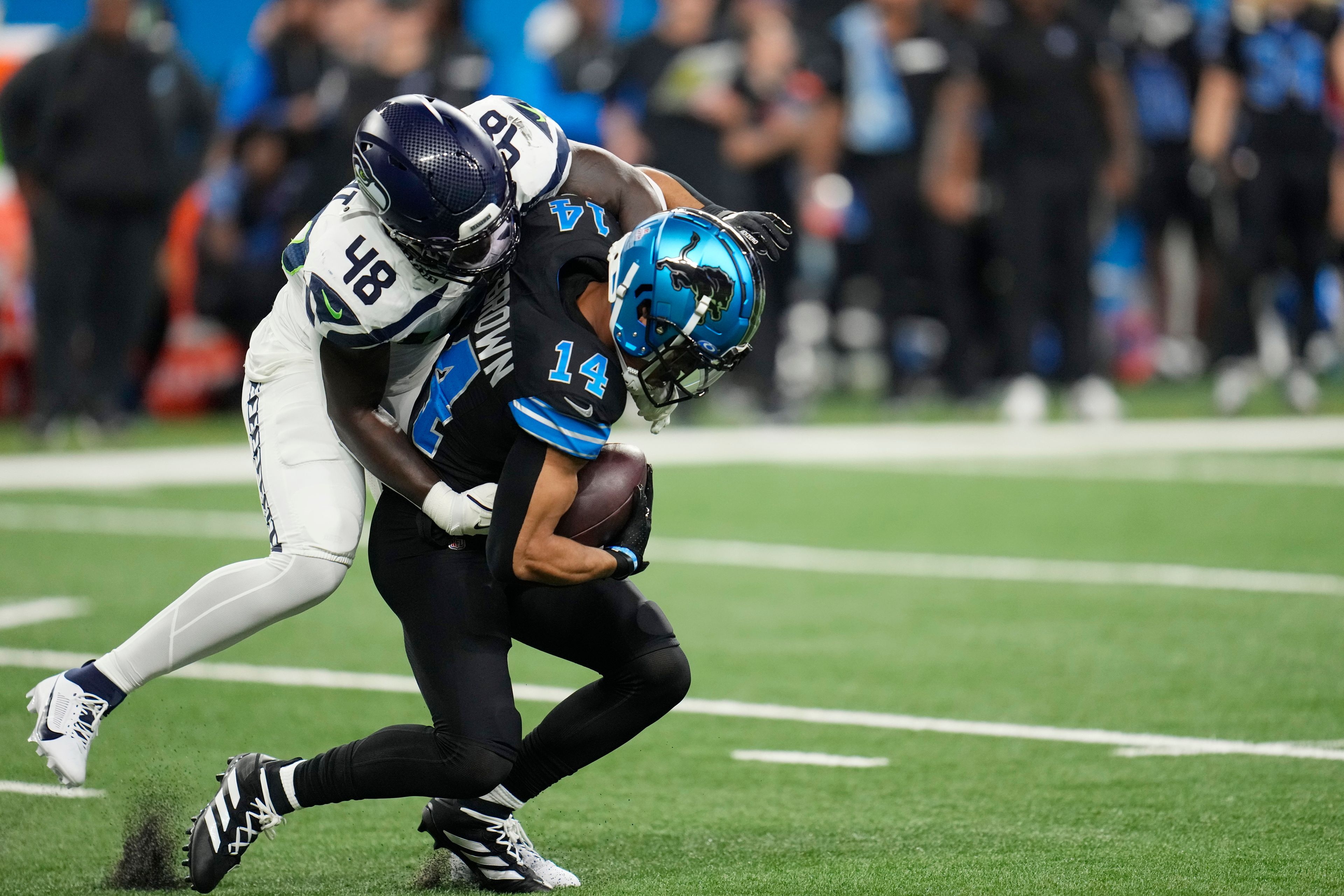 Detroit Lions wide receiver Amon-Ra St. Brown (14) is tackled by Seattle Seahawks linebacker Tyrice Knight (48) during the first half of an NFL football game, Monday, Sept. 30, 2024, in Detroit. (AP Photo/Paul Sancya)