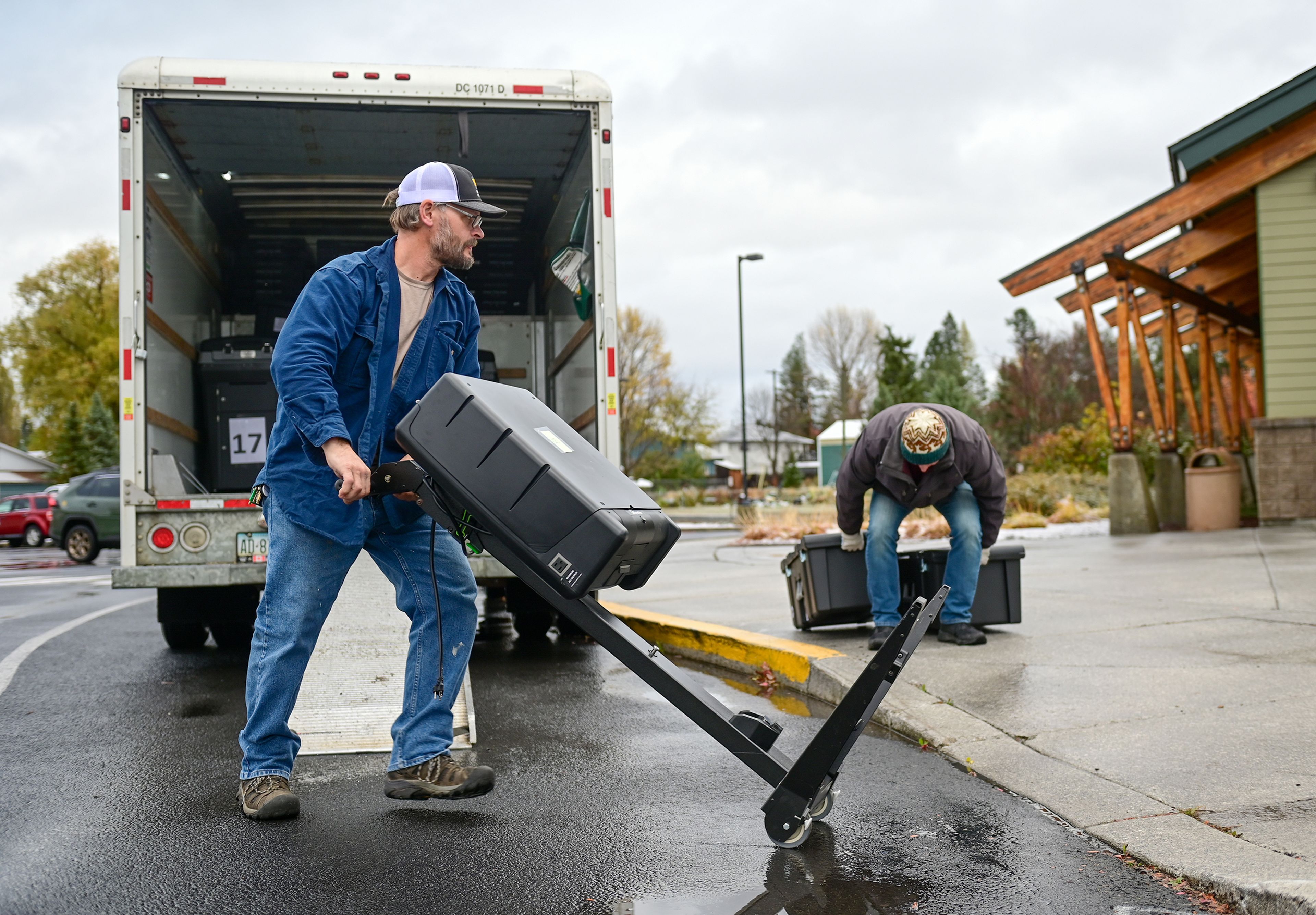 Gus Frederick, left, with the Latah County facilities department, on Monday helps move polling supplies out of a trailer at the Hamilton Indoor Recreation Center, a polling location for Latah County, in Moscow.