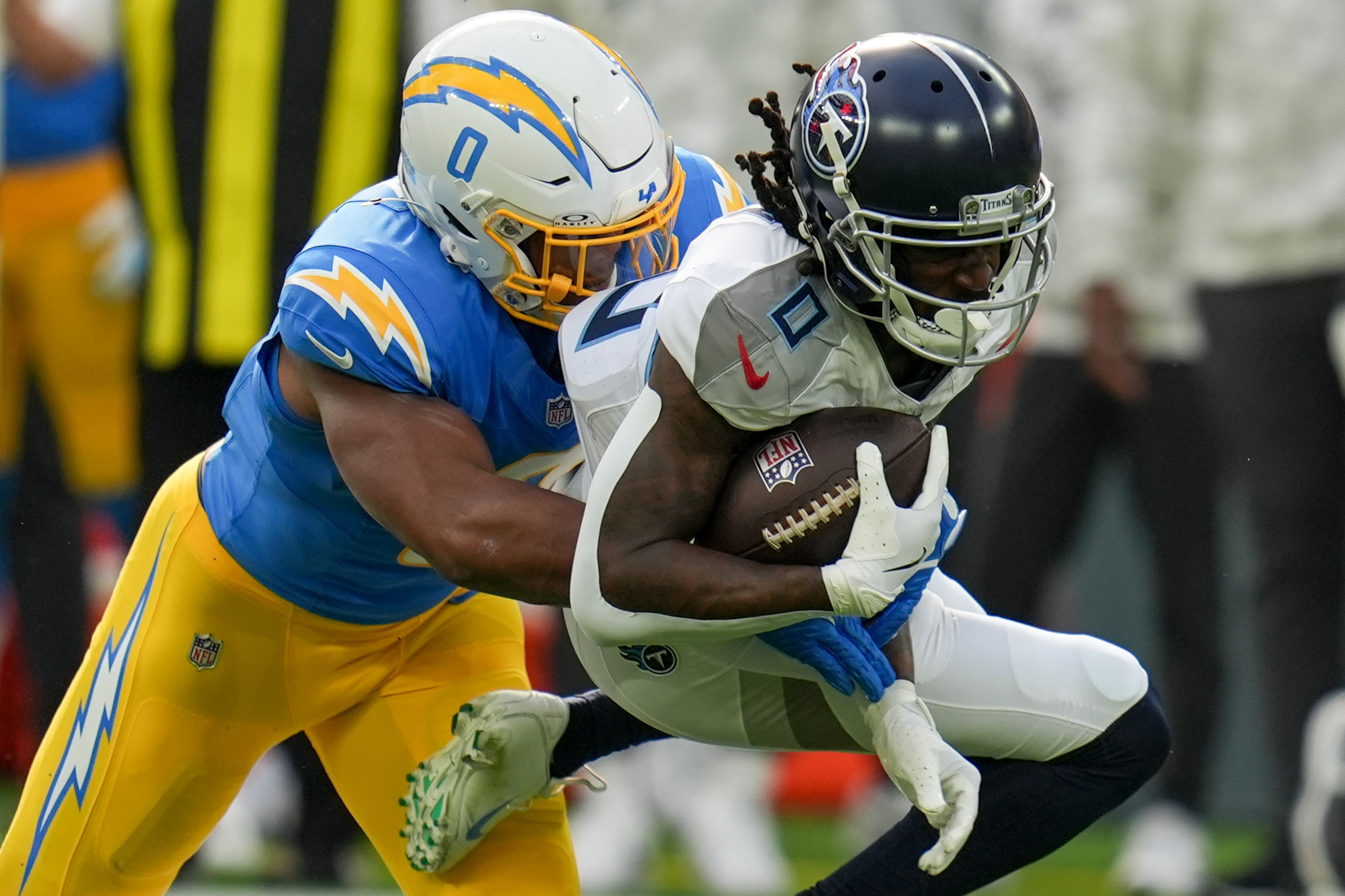 Los Angeles Chargers linebacker Daiyan Henley, left, tackles Tennessee Titans wide receiver Calvin Ridley, right, after a catch during the first half of an NFL football game Sunday, Nov. 10, 2024, in Inglewood, Calif. (AP Photo/Gregory Bull)