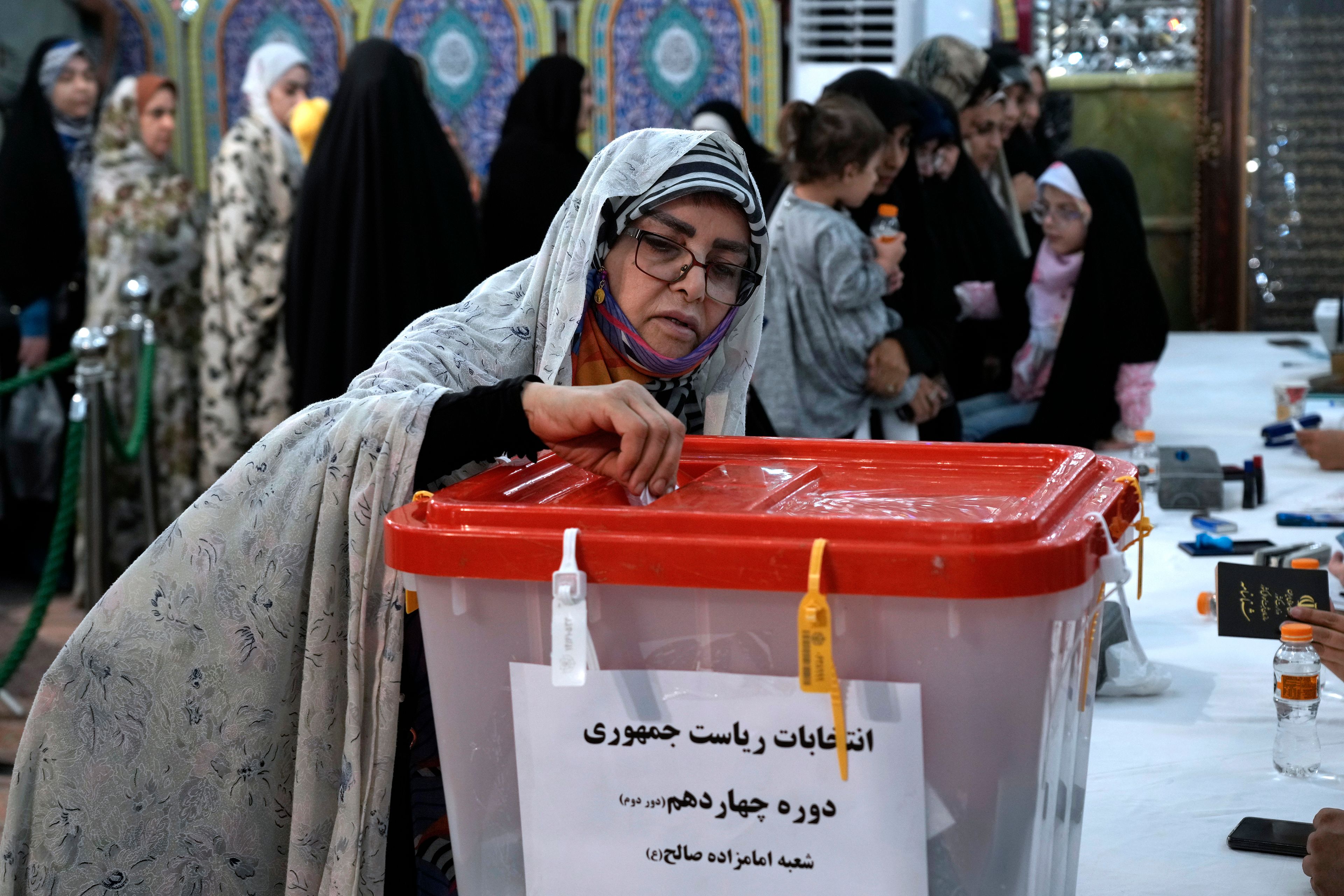 A woman casts her vote for the presidential election in a polling station at the shrine of Saint Saleh in northern Tehran, Iran, Friday, July 5, 2024. Iran held a runoff presidential election on Friday that pitted a hard-line former nuclear negotiator against a reformist lawmaker. (AP Photo/Vahid Salemi)