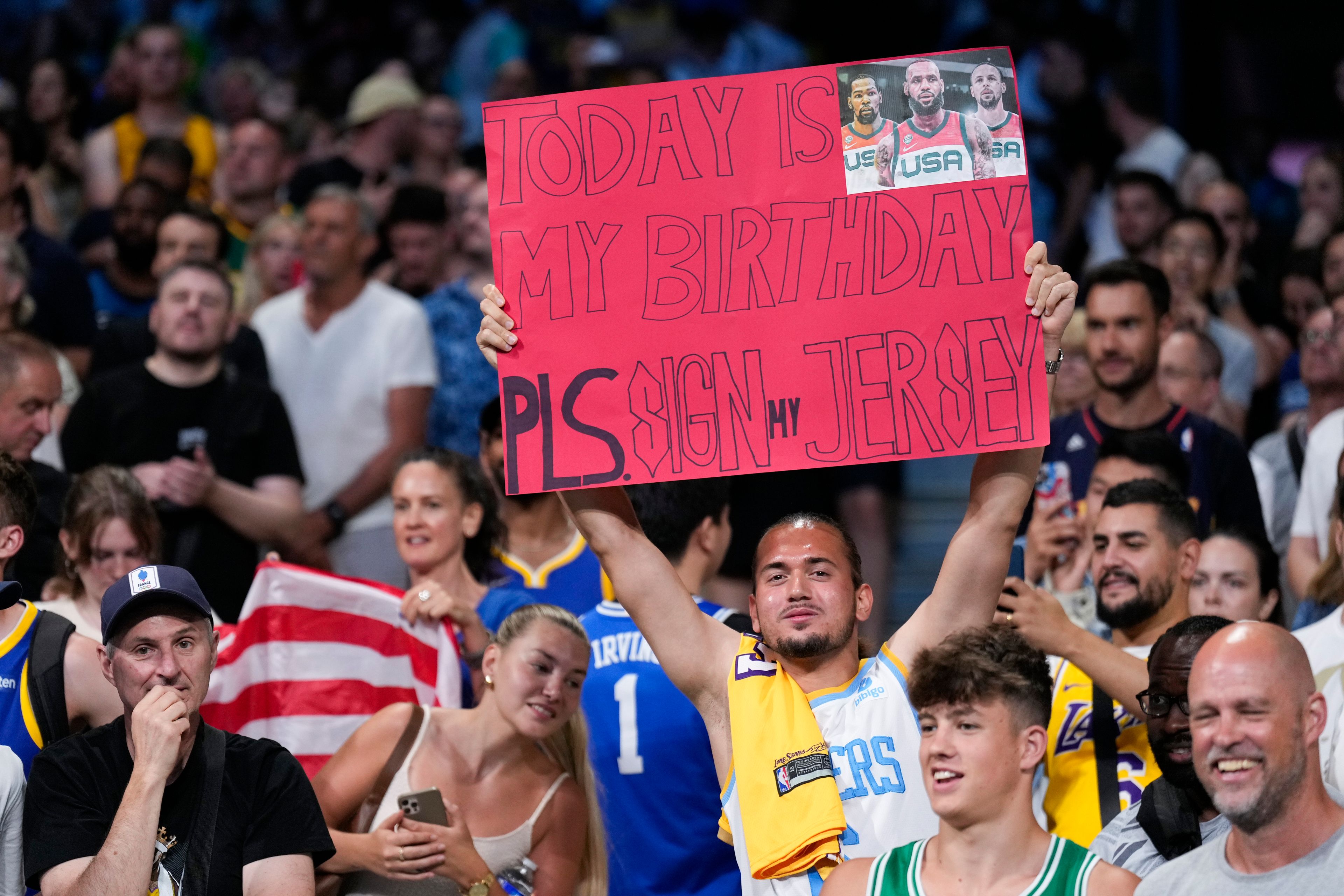 United States fans cheer before the start a men's basketball game\between the United States South Sudan at the 2024 Summer Olympics, Wednesday, July 31, 2024, in Villeneuve-d'Ascq, France. (AP Photo/Mark J. Terrill)