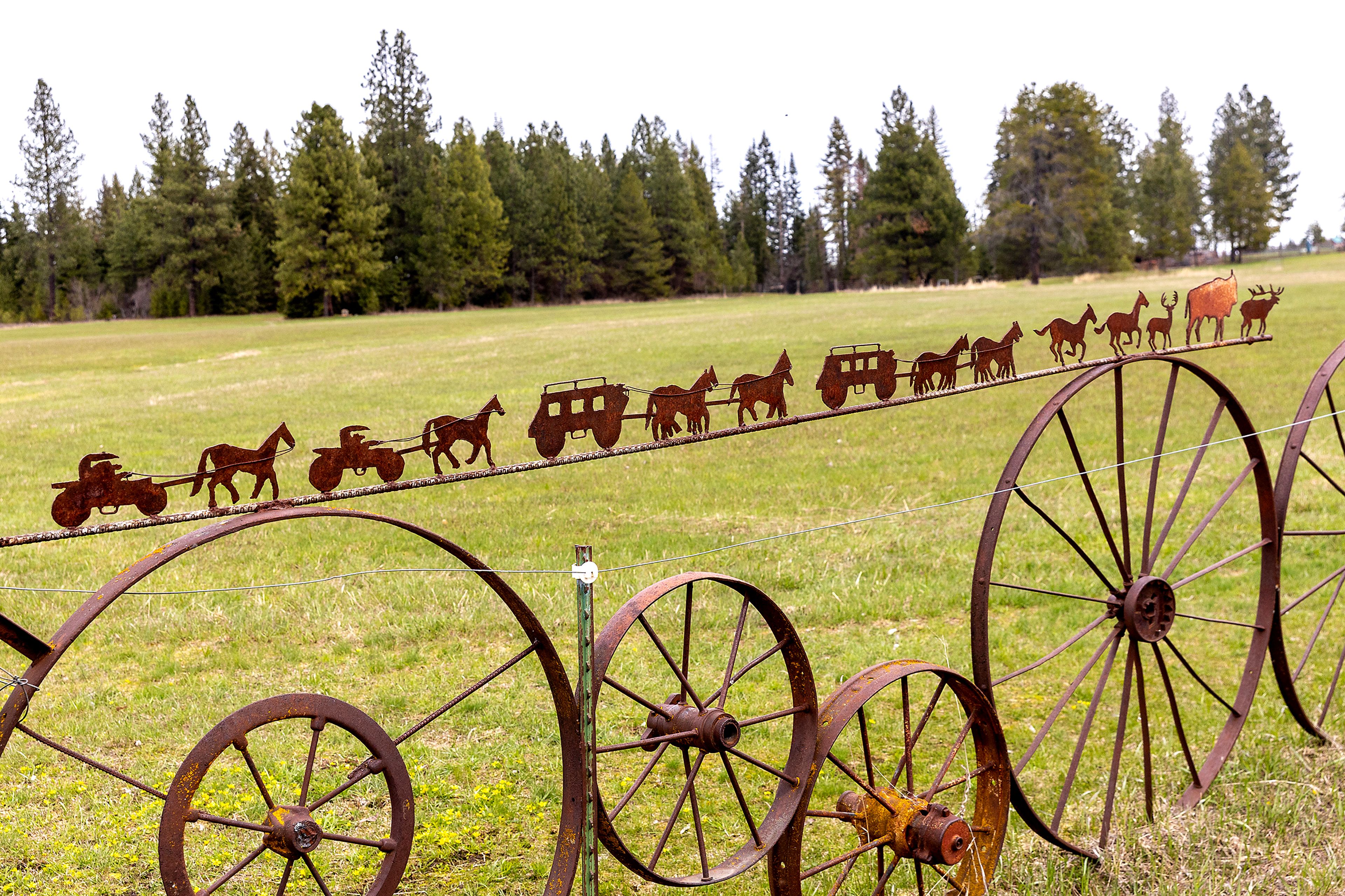 A artistic fence of wheels sits Wednesday, April 26, past Weippe.