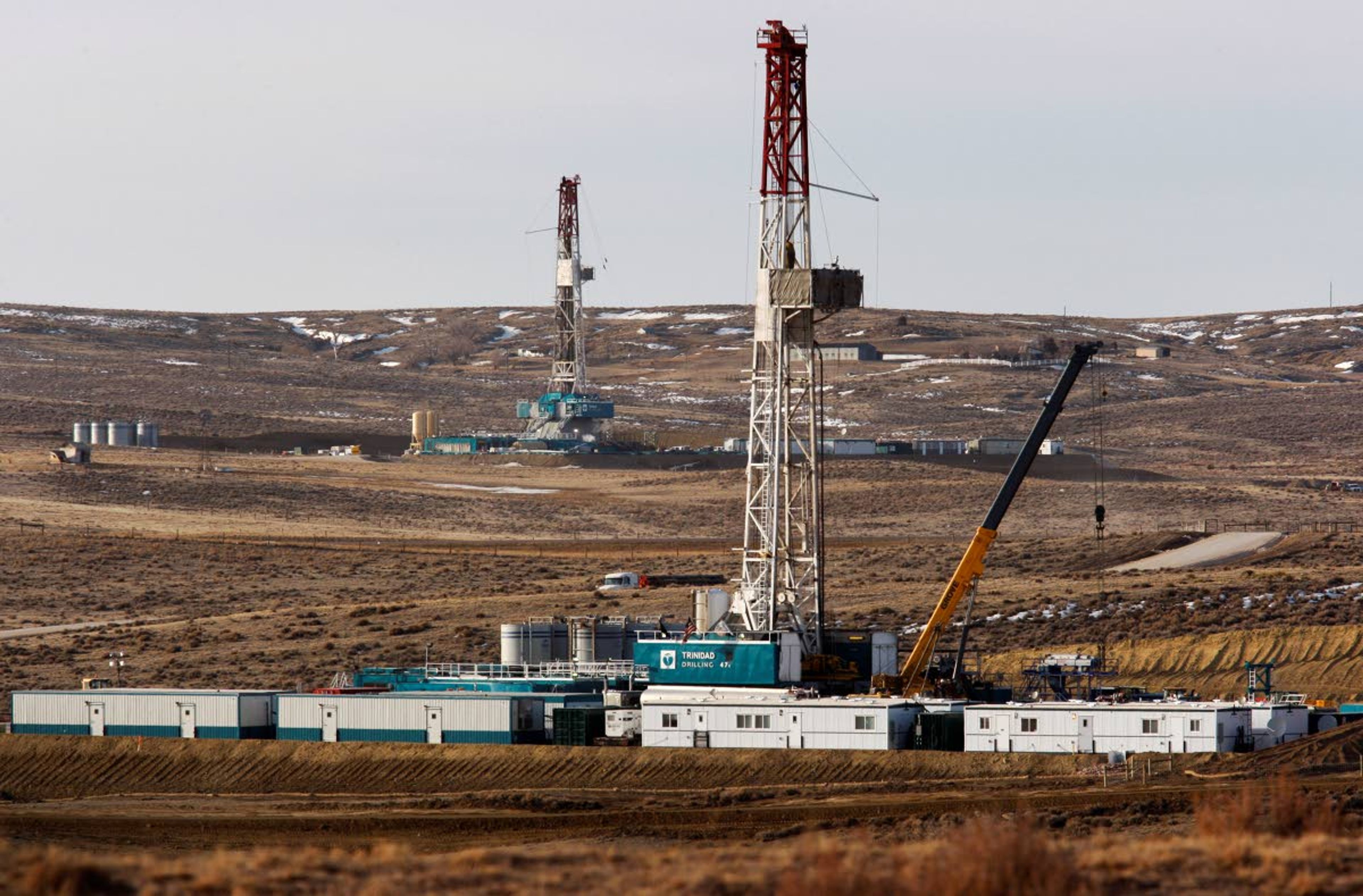 In this March 5, 2013, photo, Trinidad Drilling rigs are seen off of Way Highway 59 outside of Douglas, Wyo.