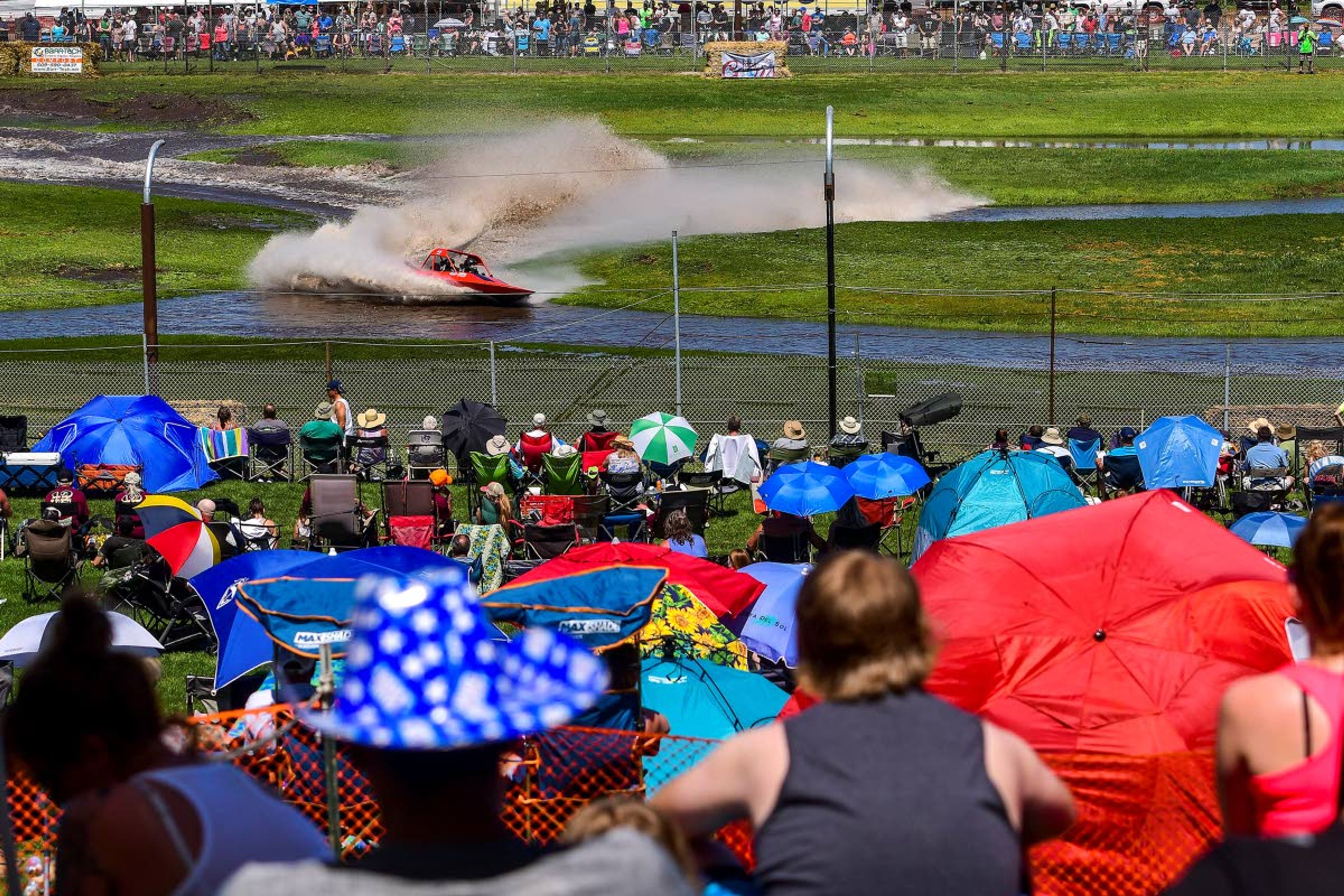 Fans surround the fenced in track of Webb's Slough as Jesse Miller and Kalyn Miller maneuver their sprint boat through the islands along the course on Saturday in St. John.