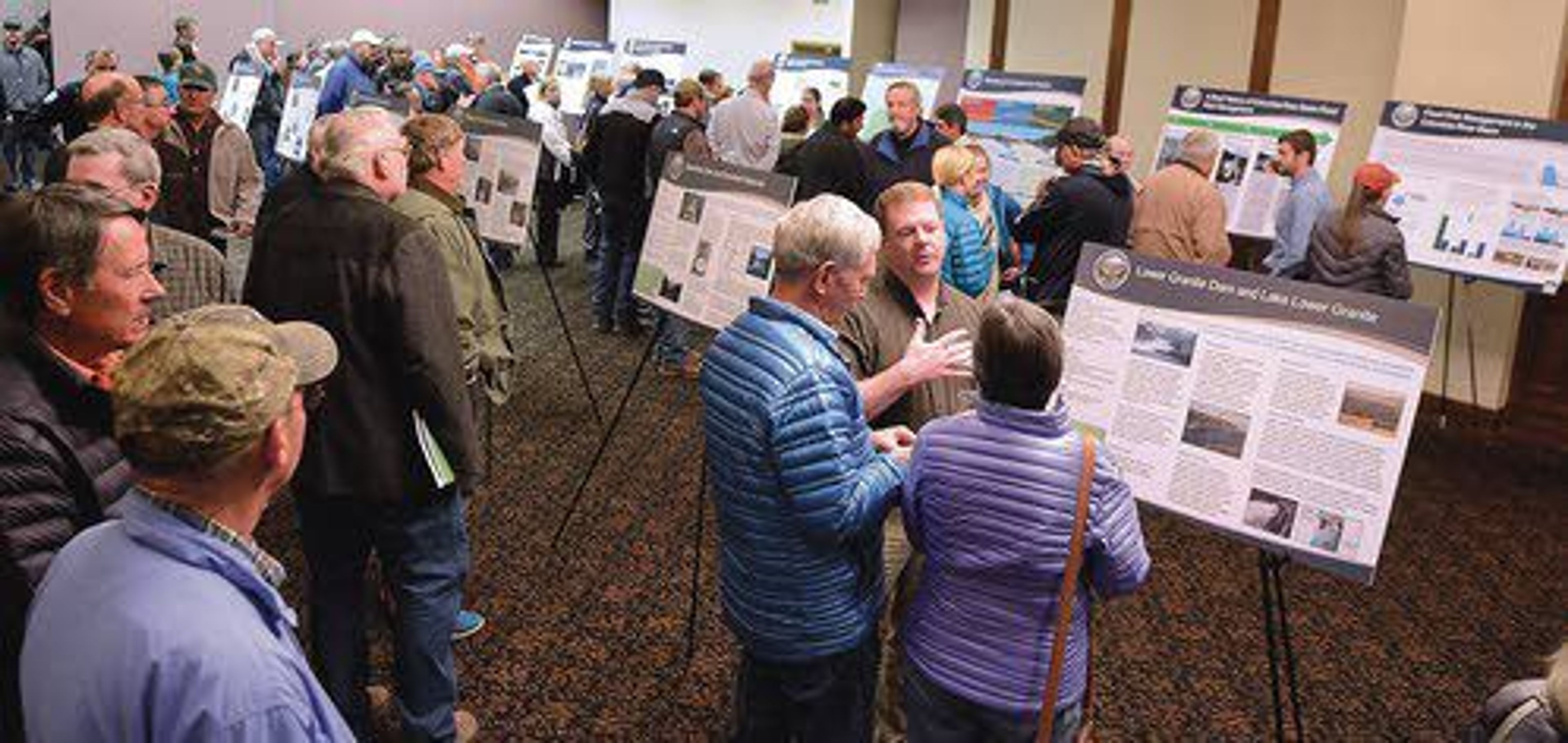 Visitors to the Red Lion Hotel in Lewiston Wednesday look over Columbia River Systems Operations material on display.