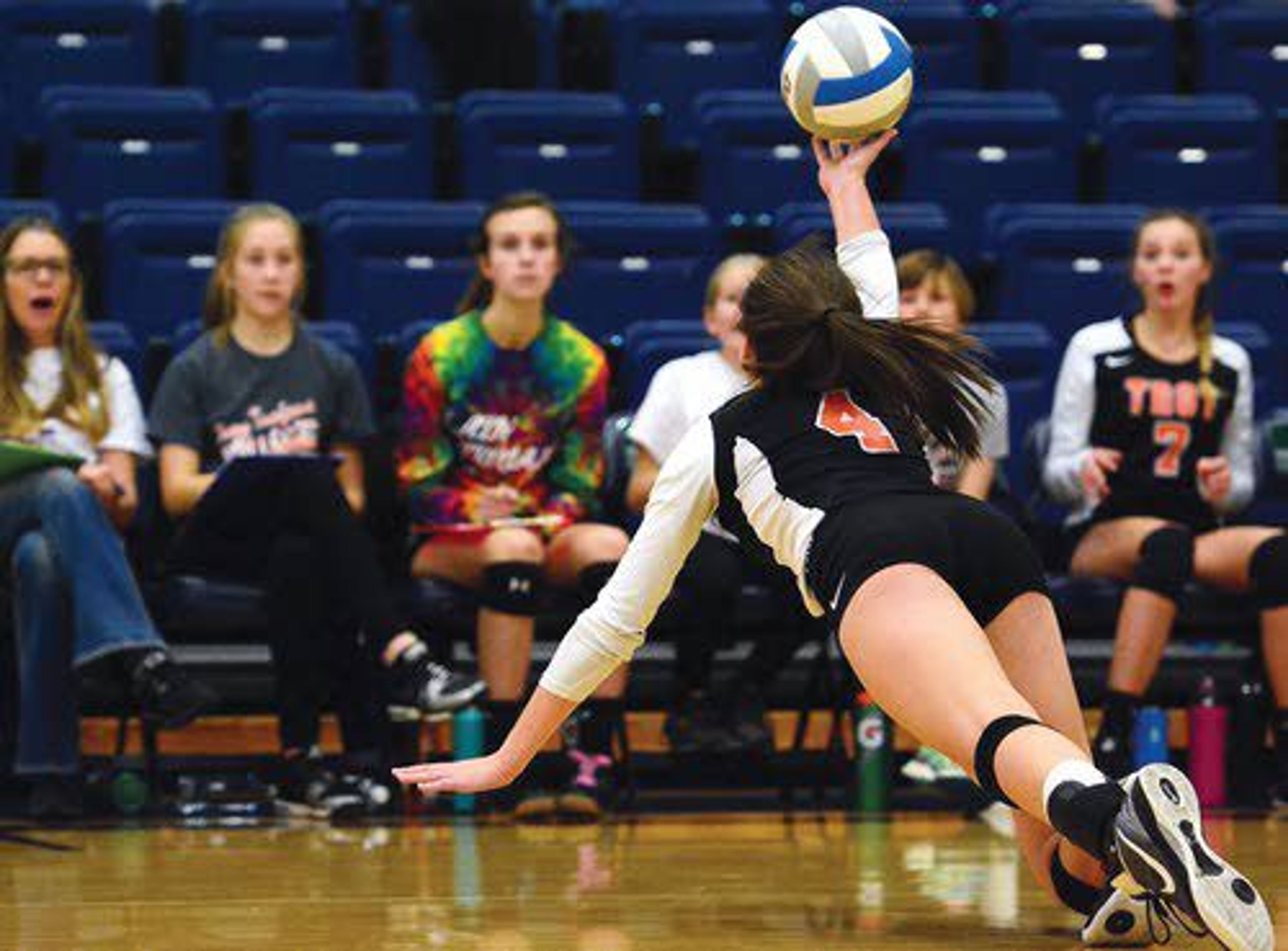 Troy outside hitter Lindsey Kwate dives to dig a ball in front of her bench during the third set. Kwate finished with 28 kills to help the Trojans knock off Genesee in the district title match.