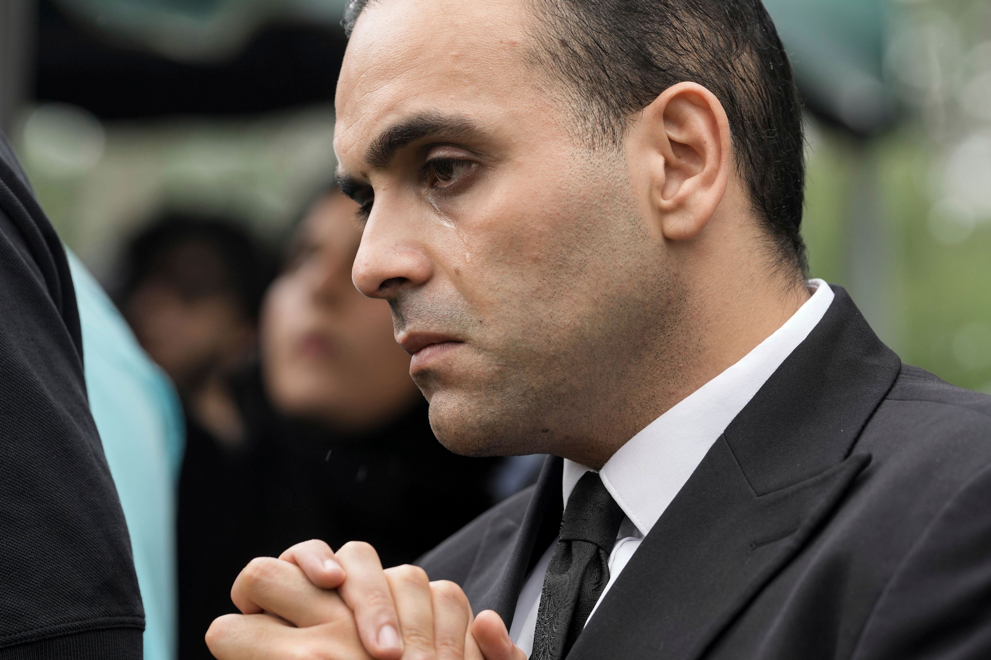 A man cries as slain Harris County Precinct 4 Deputy Constable Maher Husseini is lowered into the ground for burial, Thursday, Sept. 5, 2024, at Forest Park The Woodlands Funeral Home & Cemetery in The Woodlands, Texas.