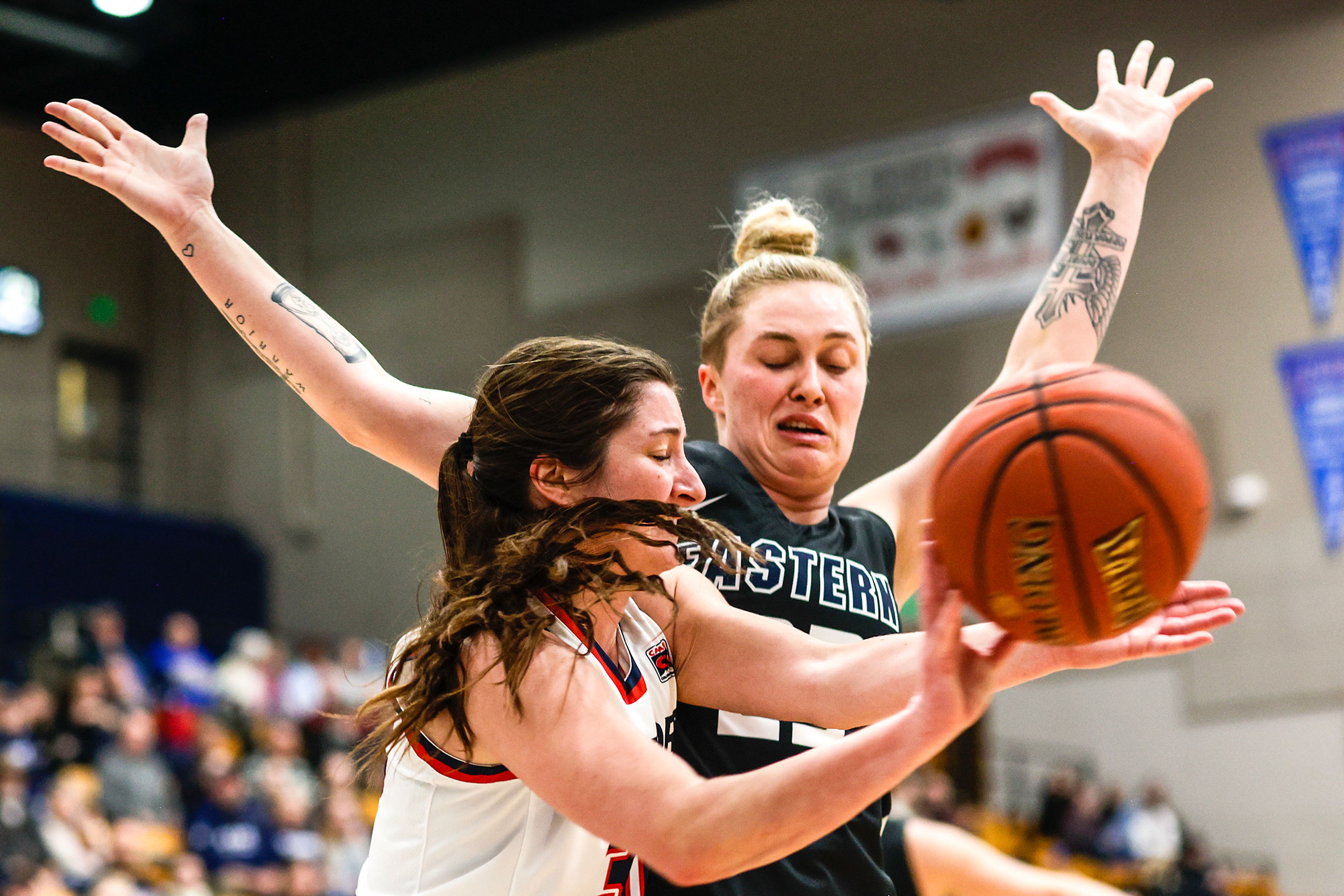 Lewis-Clark State guard Hannah Broyles passes the ball as Eastern Oregon guard Beverly Slater defends during a Cascade Conference game Friday at Lewis-Clark State College.