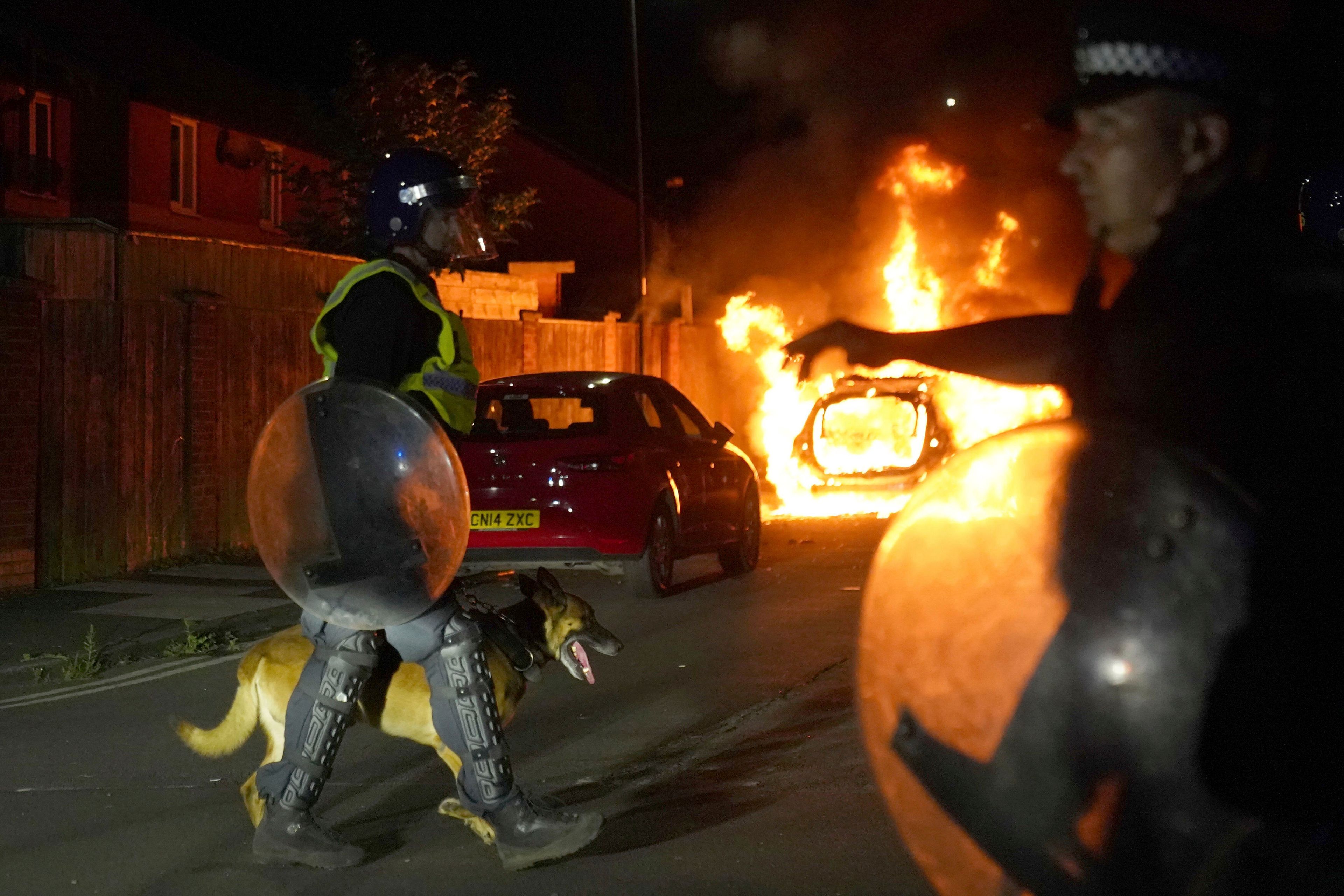 A police car burns as police officers are deployed on the streets of Hartlepool, England, following a violent protest in the wake of the killing of three girls who were fatally stabbed in northwest England, Wednesday, July 31, 2024. Far-right groups seek to stir anger over an attack they have sought to link — without evidence — to immigrants. (Owen Humphreys/PA via AP)