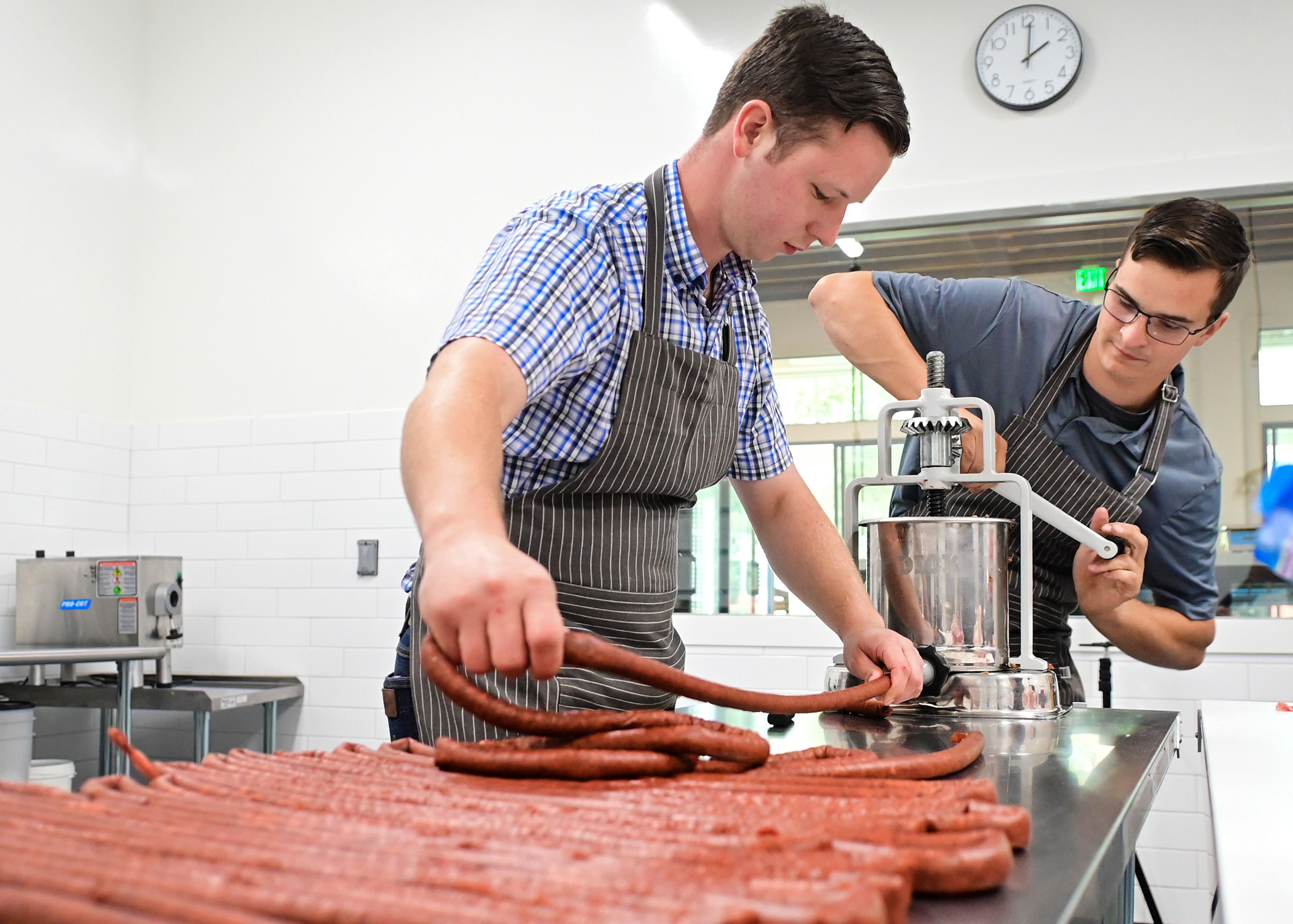 Simeon Borman, left, and Hank Moore stuff meat sticks at The Butcher Shop on Friday in Deary.