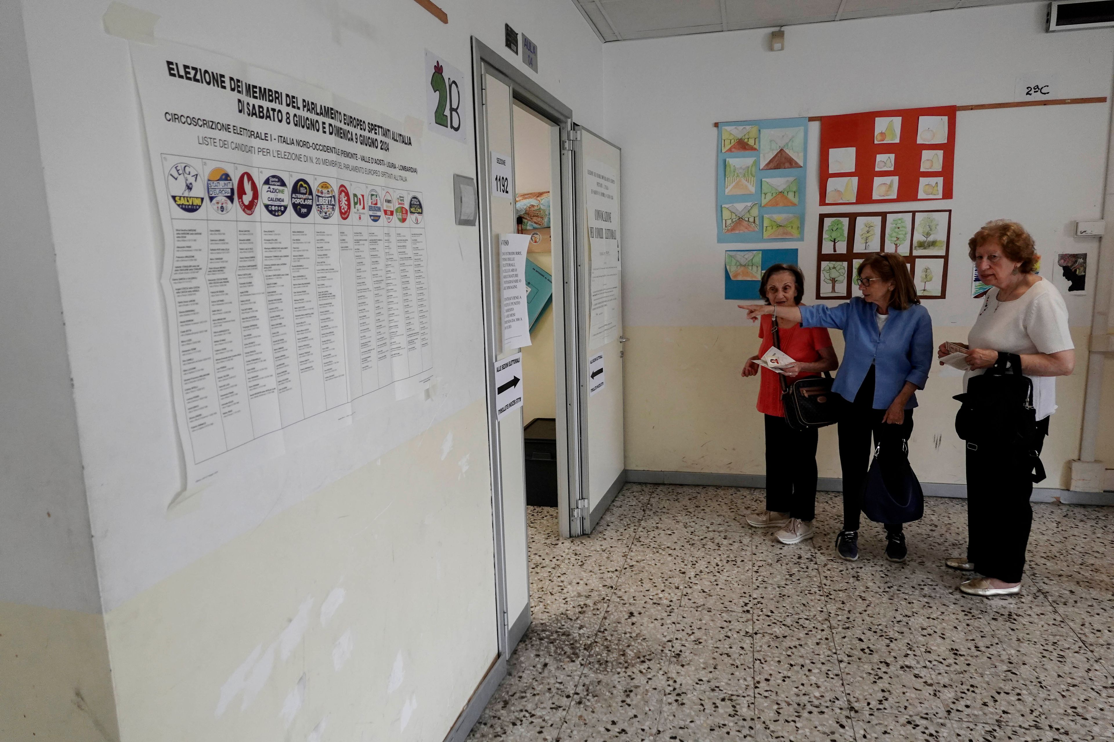 Women talk before entering a polling station in Milan, Italy, Sunday, June 9, 2024. Tens of millions across the European Union were voting in EU parliamentary elections on Sunday in a massive exercise of democracy that is expected to shift the bloc to the right and redirect its future.