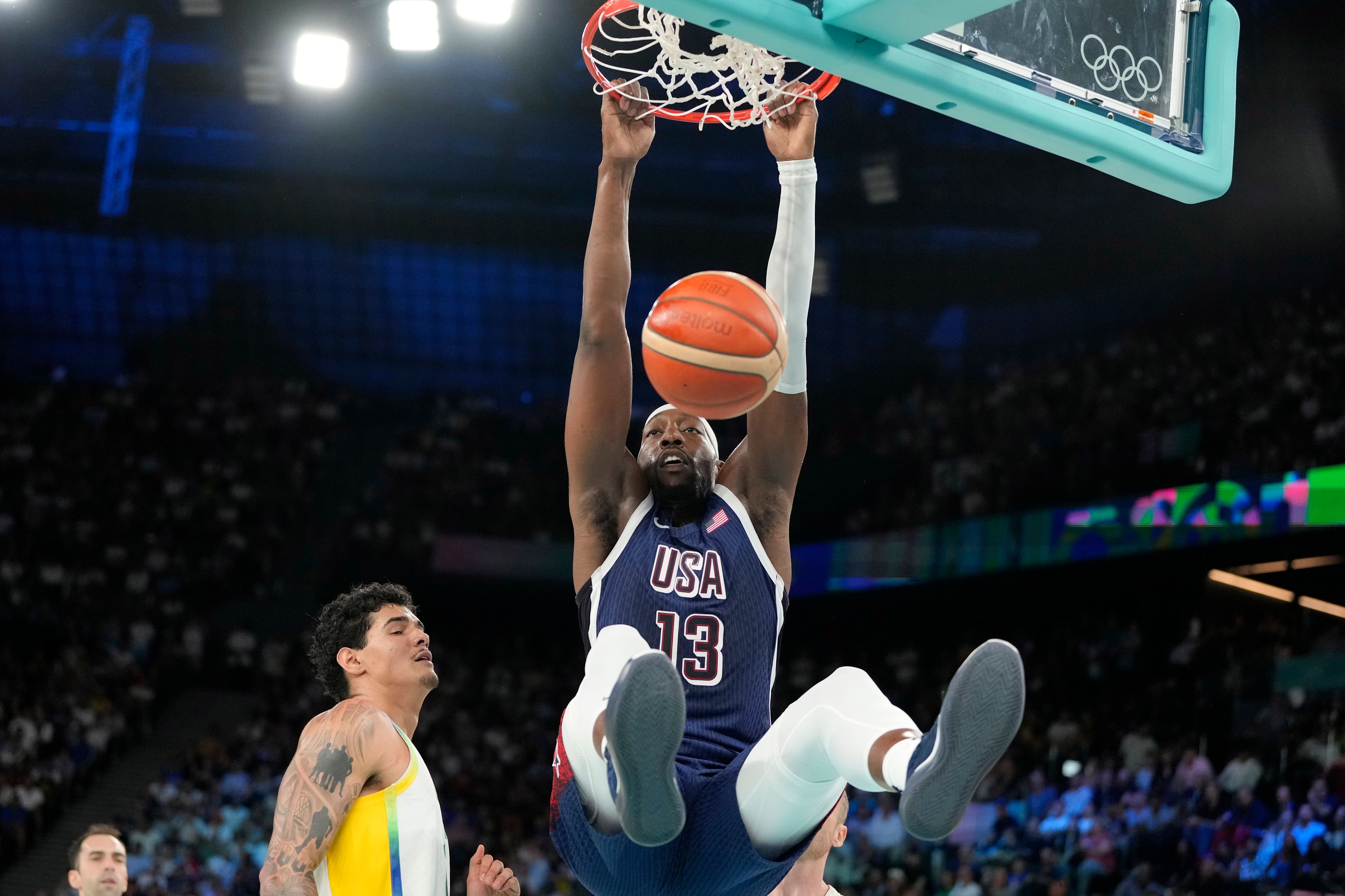 United States' Bam Adebayo, right, dunks as Brazil's Gui Santos defends during a men's basketball game at the 2024 Summer Olympics, Tuesday, Aug. 6, 2024, in Paris, France. (AP Photo/Michael Conroy)