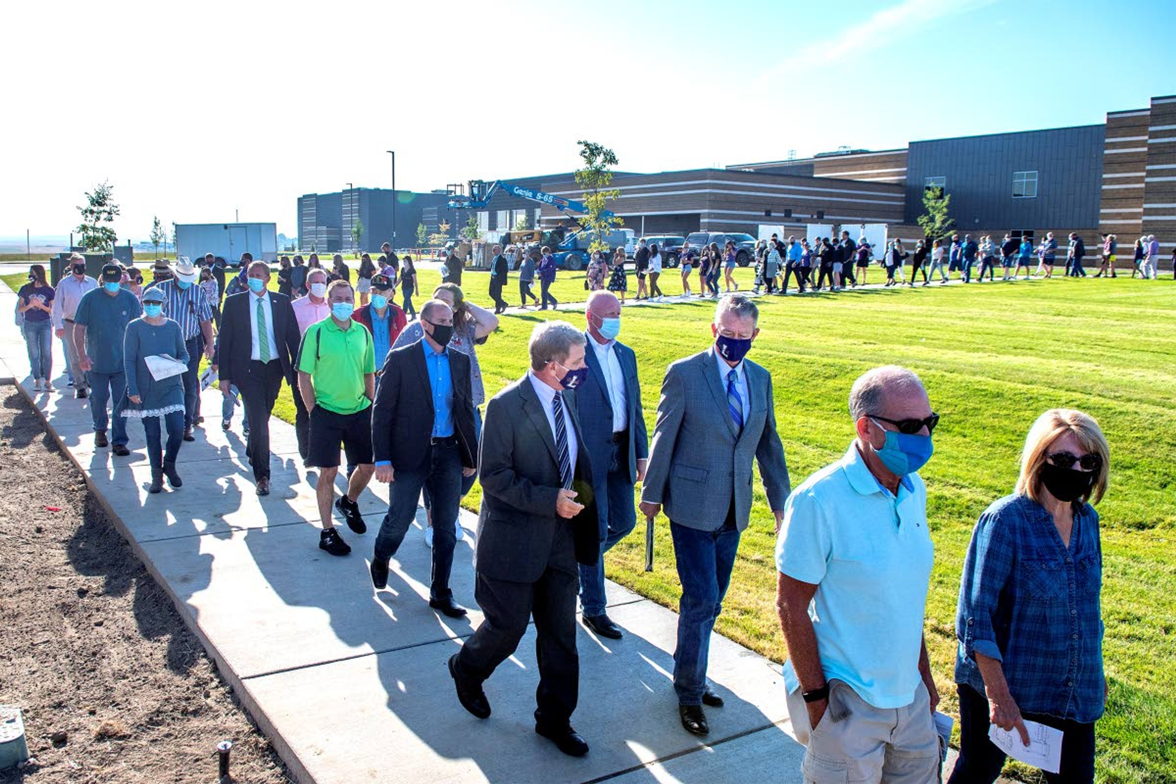 Lewiston Superintendent Bob Donaldson (left) talks with Idaho Gov. Brad Little as they make their way toward the career technical education center for its ribbon-cutting following a similar ceremony at the new Lewiston High School behind them Friday morning.