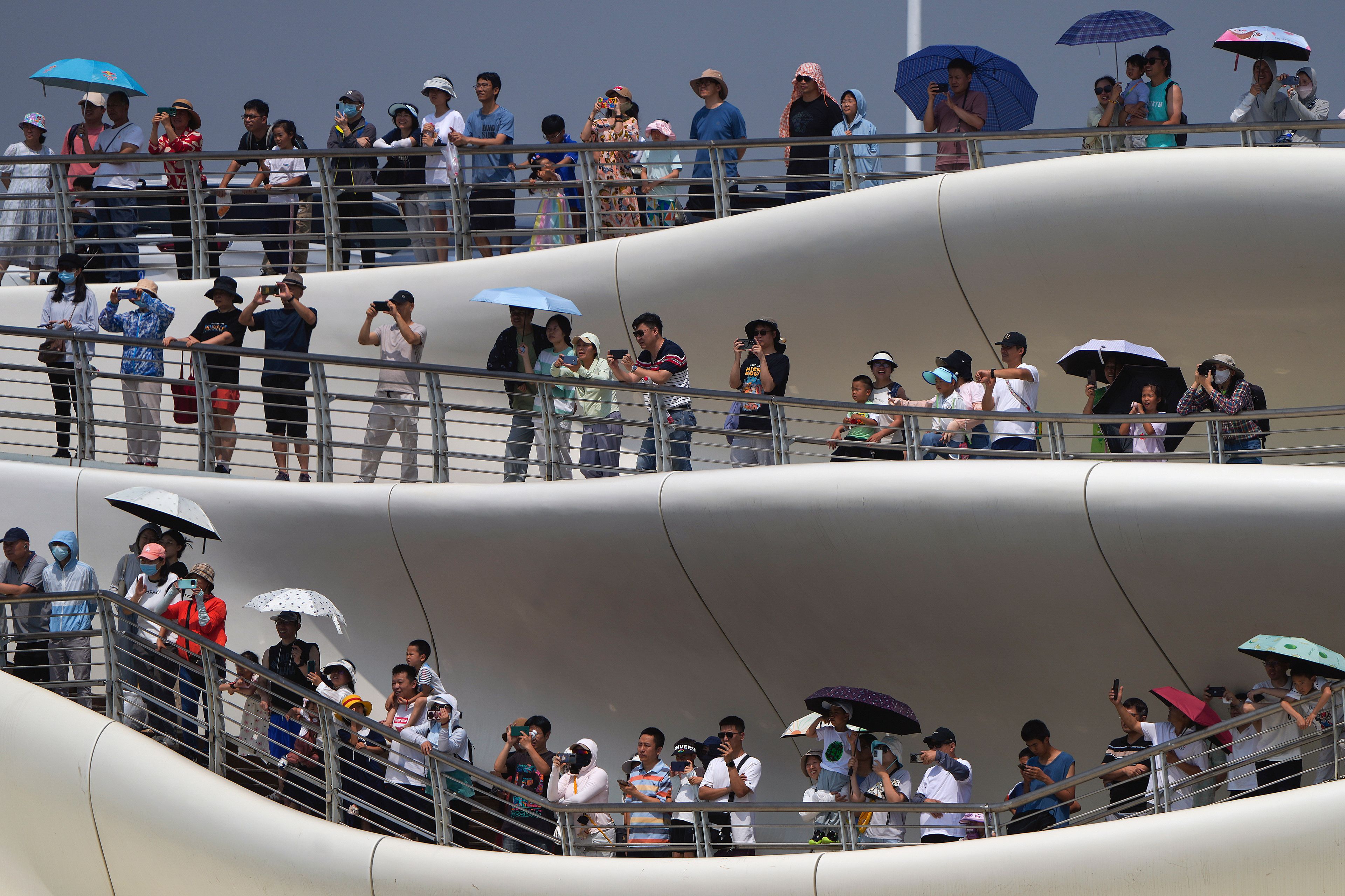 People stand on a bridge to watch the dragon boat races during the Dragon Boat Festival at a canal in Tongzhou, outskirts of Beijing, Monday, June 10, 2024. The Duanwu Festival, also known as the Dragon Boat Festival, falls on the fifth day of the fifth month of the Chinese lunar calendar and is marked by eating rice dumplings and racing dragon boats.