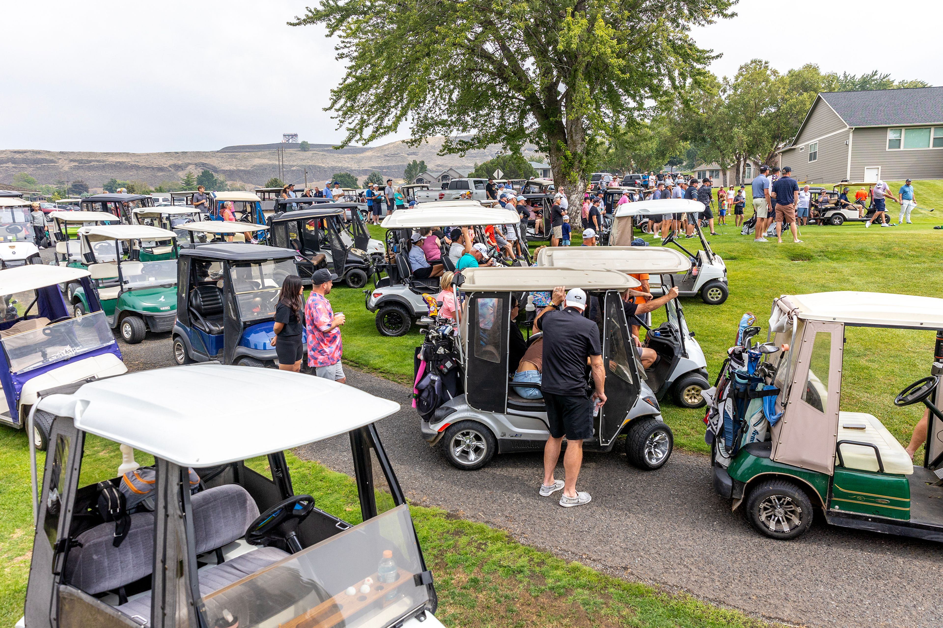 A legion of golf carts watch competitors tee off on the first hole of the Sole Survivor Tournament Monday at the Lewiston Golf and Country Club.