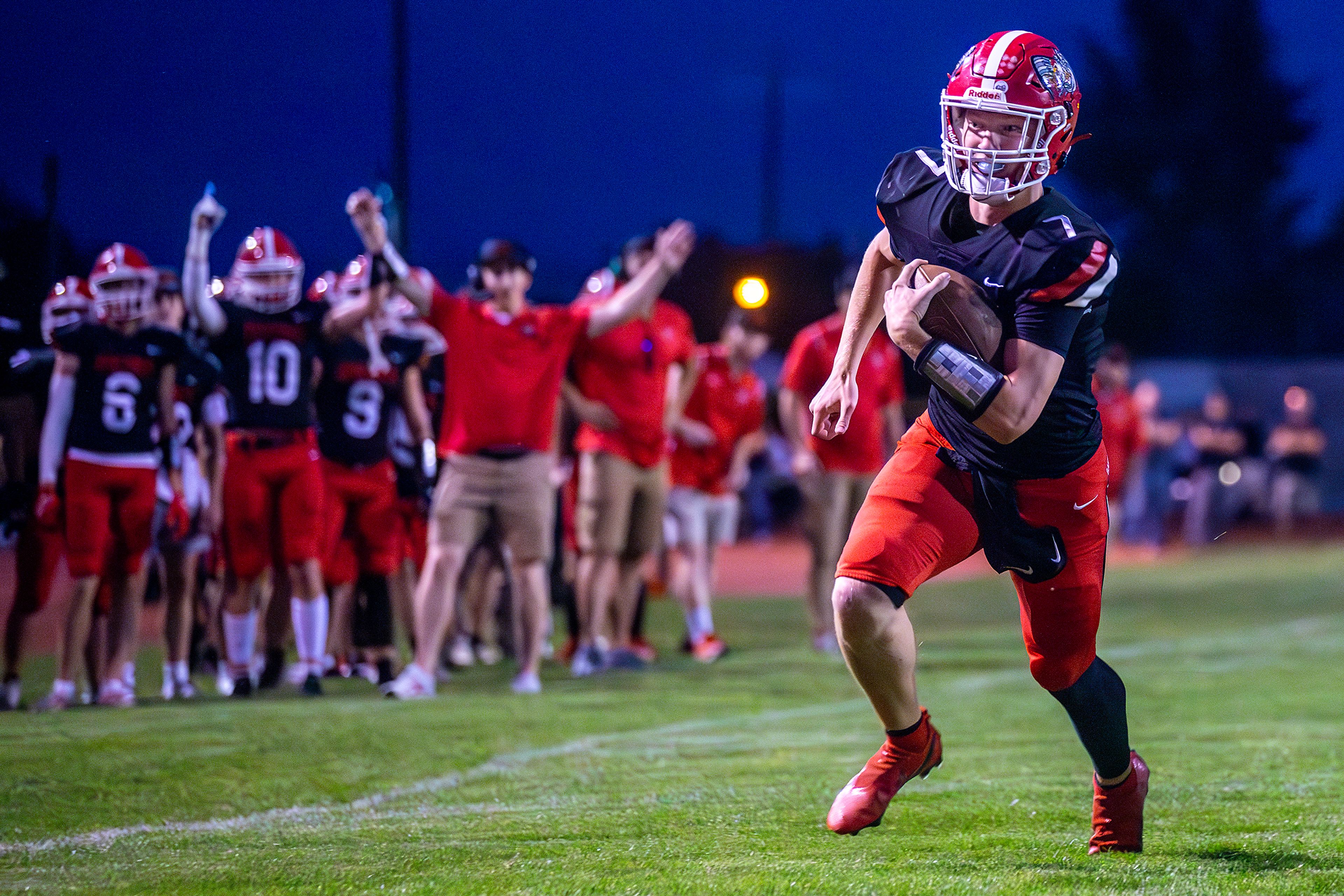 Clarkston Quarterback Hayden Line runs the ball in for a touchdown against Rogers during a Thursday night football game in Clarkston.