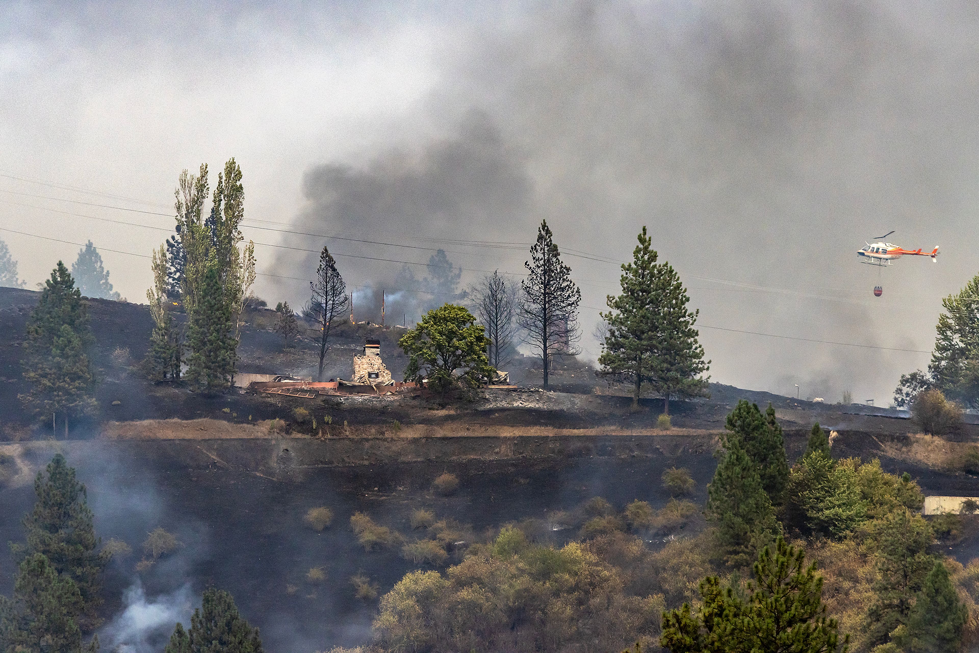 A helicopter makes drops on a fire off of Dent Bridge Road Tuesday near Orofino.