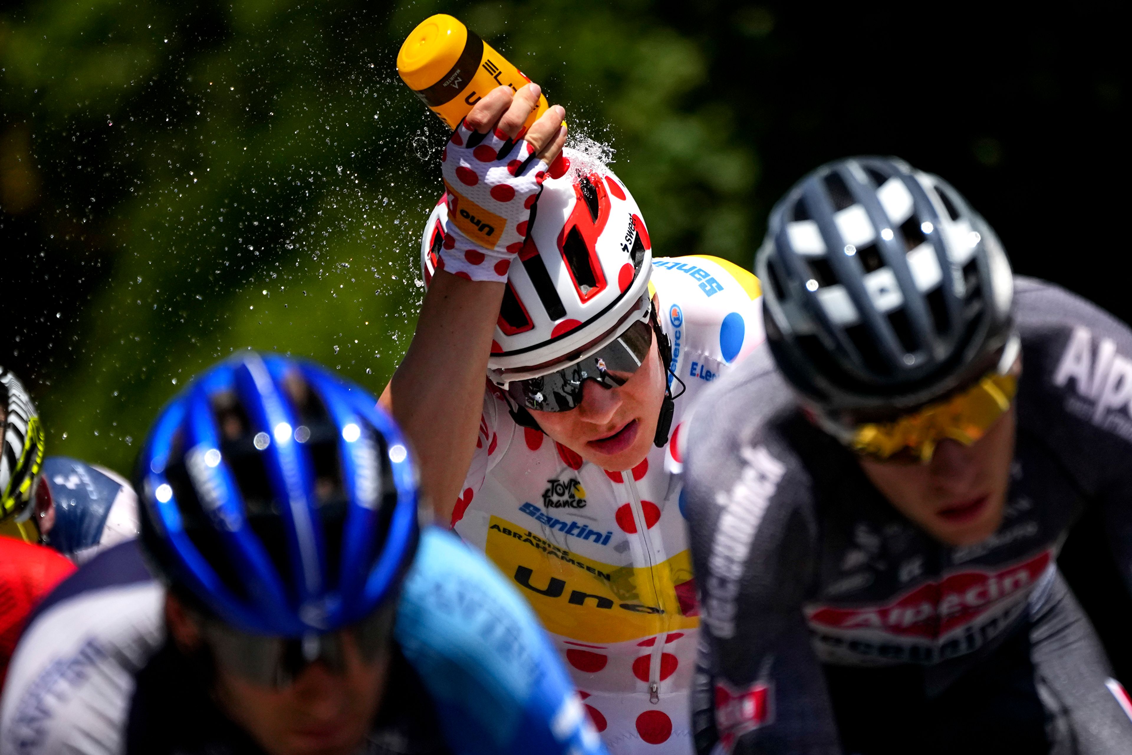 Uno-X Mobility’s Jonas Abrahamsen, of Norway, wearing the polka dot jersey, cools off while riding in the breakaway during the second stage of the Tour de France over 199.2 kilometers with start in Cesenatico and finish in Bologna, Italy, Sunday, June 30, 2024. The polka dot jersey denotes the leader of the mountain classification for which points are awarded for the first rider to reach the mountain summits. (AP Photo/Daniel Cole)