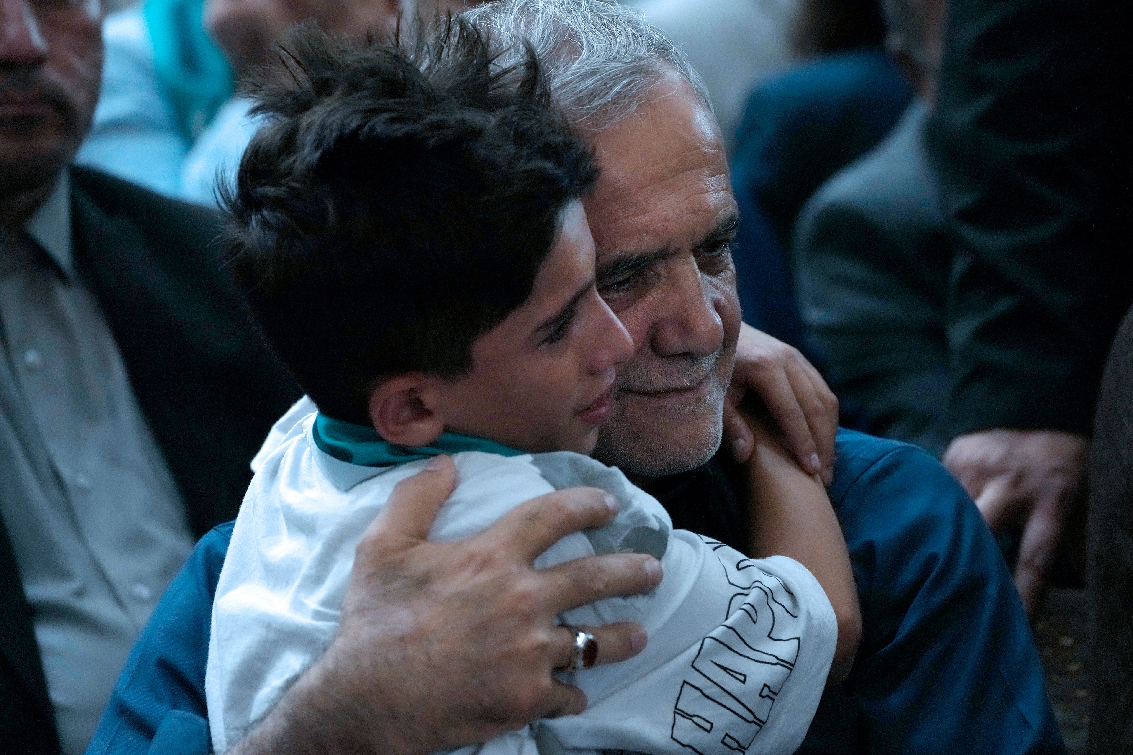 Iran's President-elect Masoud Pezeshkian hugs a boy in a meeting a day after the presidential election, at the shrine of the late revolutionary founder Ayatollah Khomeini, just outside Tehran, Iran, Saturday, July 6, 2024. (AP Photo/Vahid Salemi)