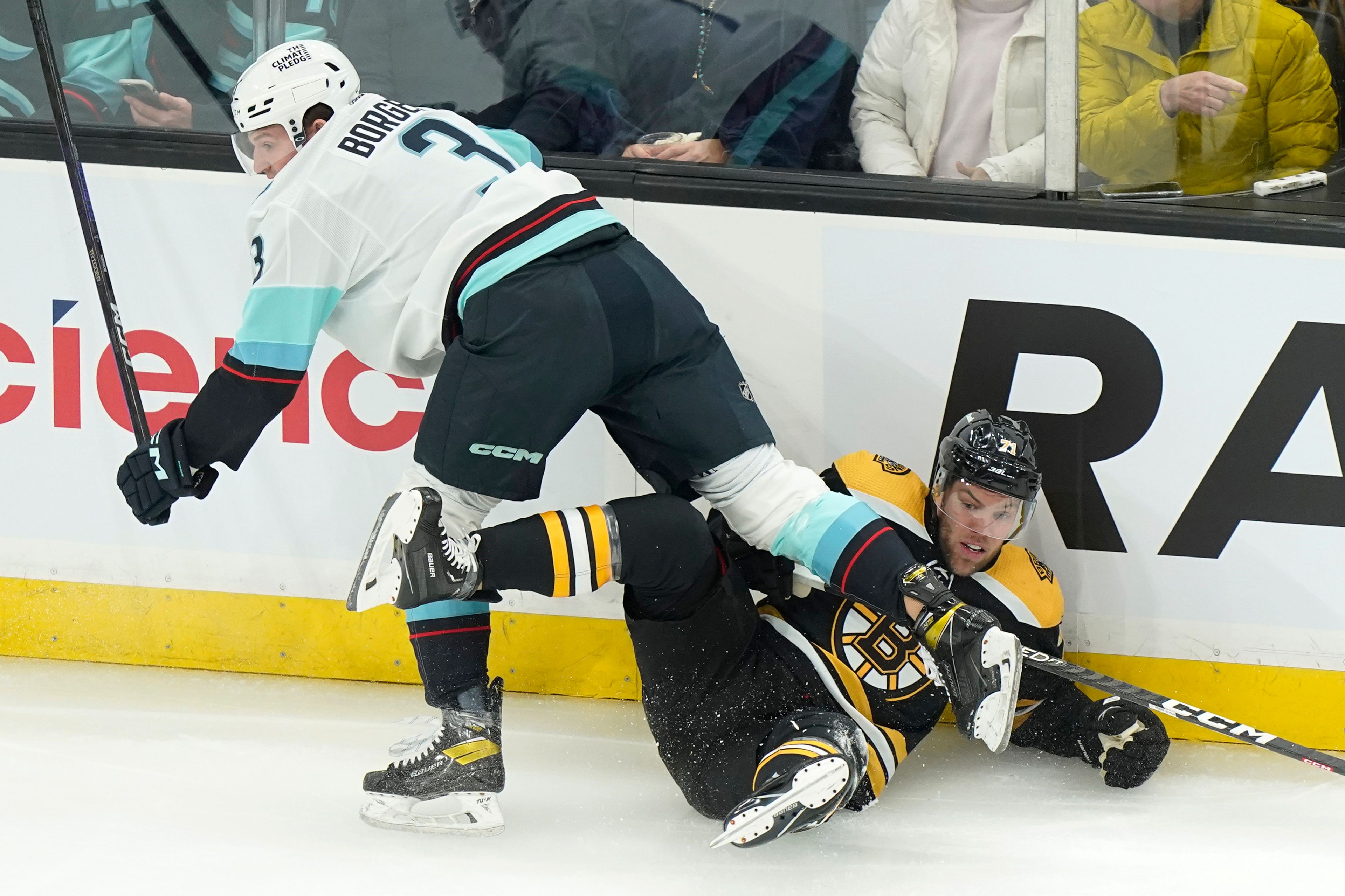 Seattle Kraken defenseman Will Borgen (3) and Boston Bruins left wing Taylor Hall, right, crash into the boards after colliding during the first period of an NHL hockey game Thursday, Jan. 12, 2023, in Boston. (AP Photo/Steven Senne)