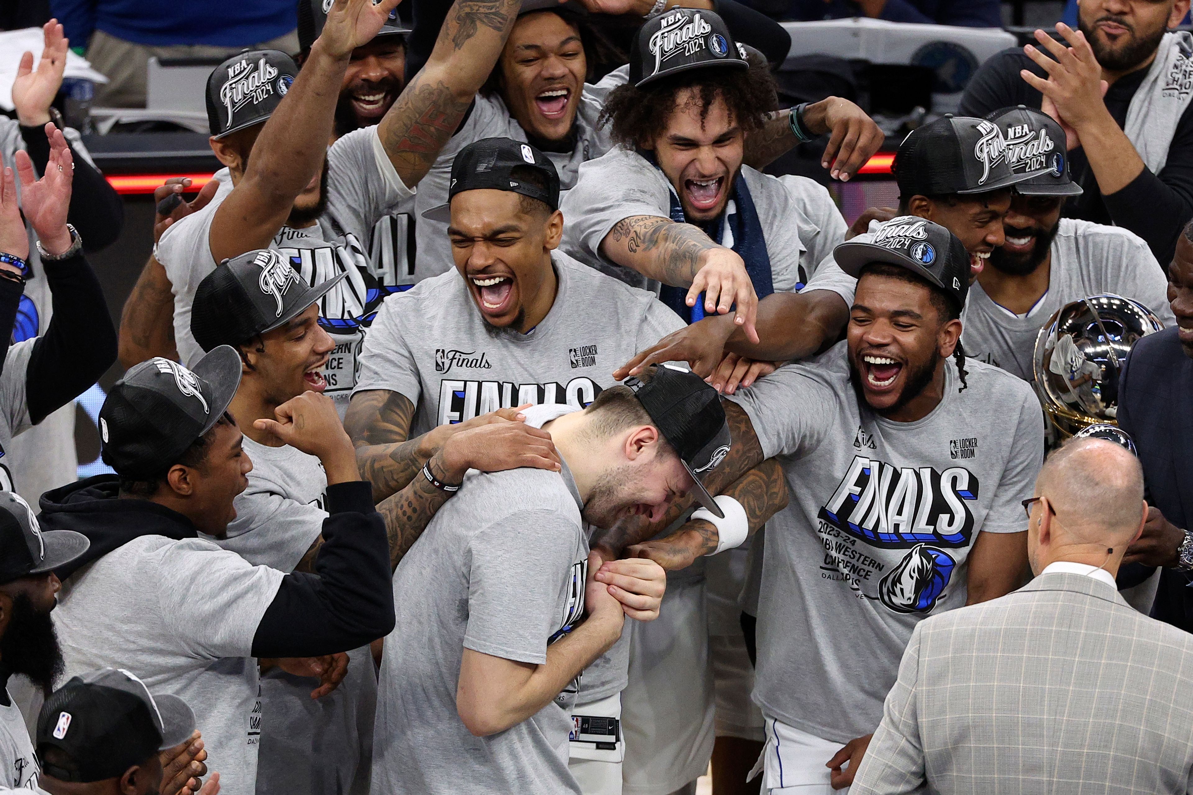 Mavericks guard Luka Doncic, center, celebrates with teammates after Game 5 of the Western Conference finals in the NBA playoffs against the Timberwolves on Thursday in Minneapolis. The Mavericks won 124-103, taking the series 4-1 and moving on to the NBA Finals.