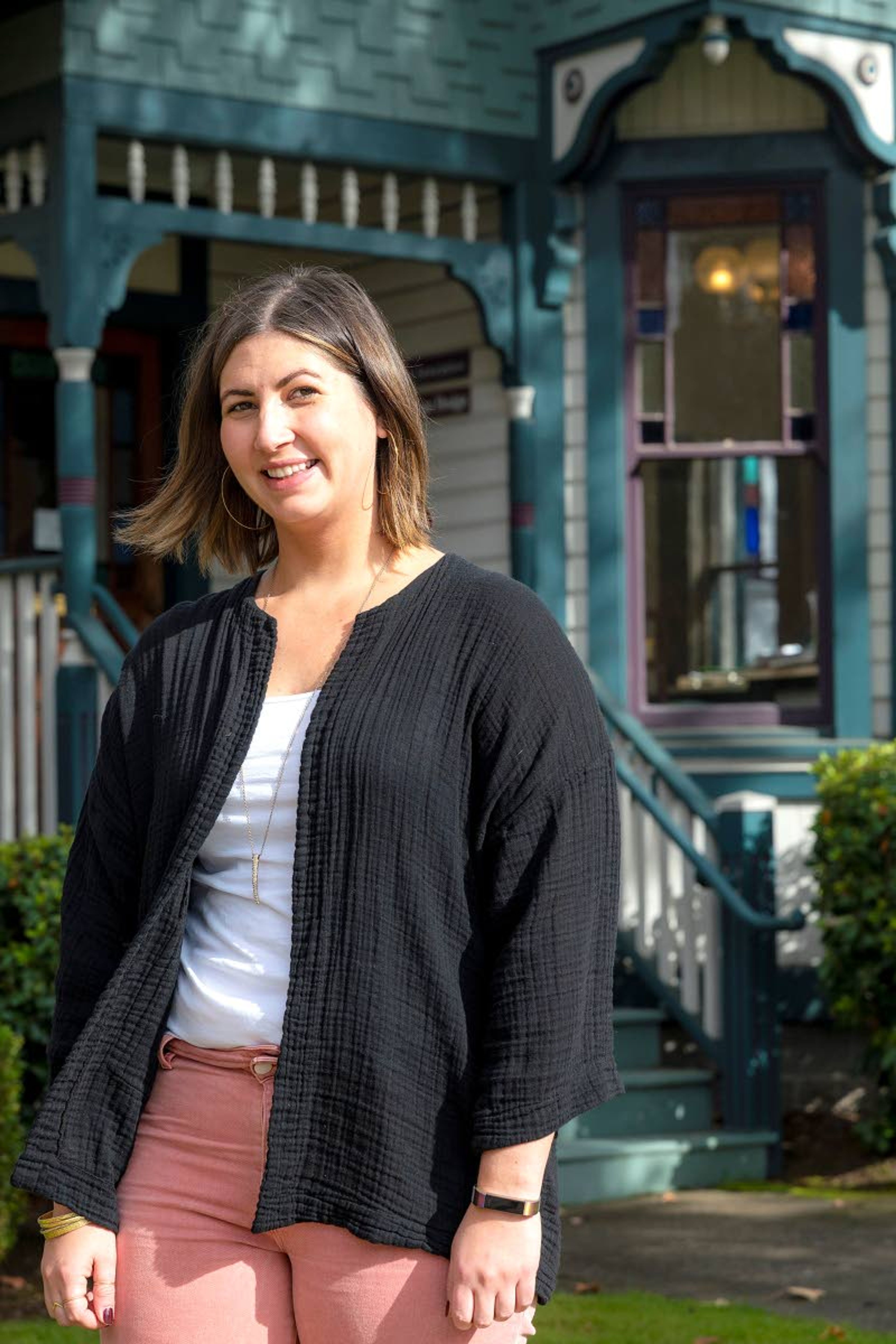 Tayler Brisbin, the communications and events manager with the McMinnville Downtown Association, poses for a portrait outside the group’s office in an old Victorian house at the west end of downtown.