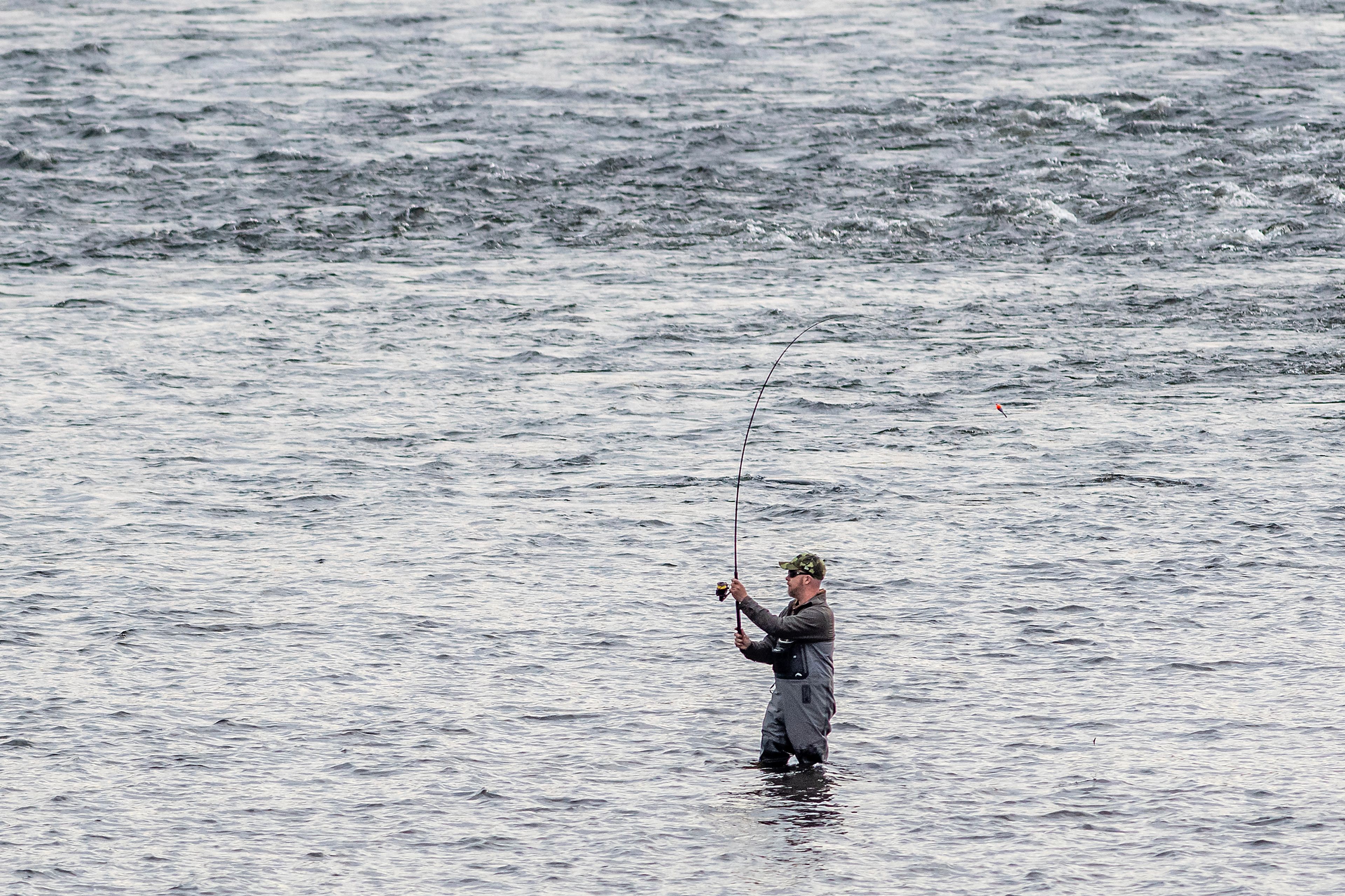 An angler fishes Monday on the Clearwater River nearby Cherrylane Bridge.,