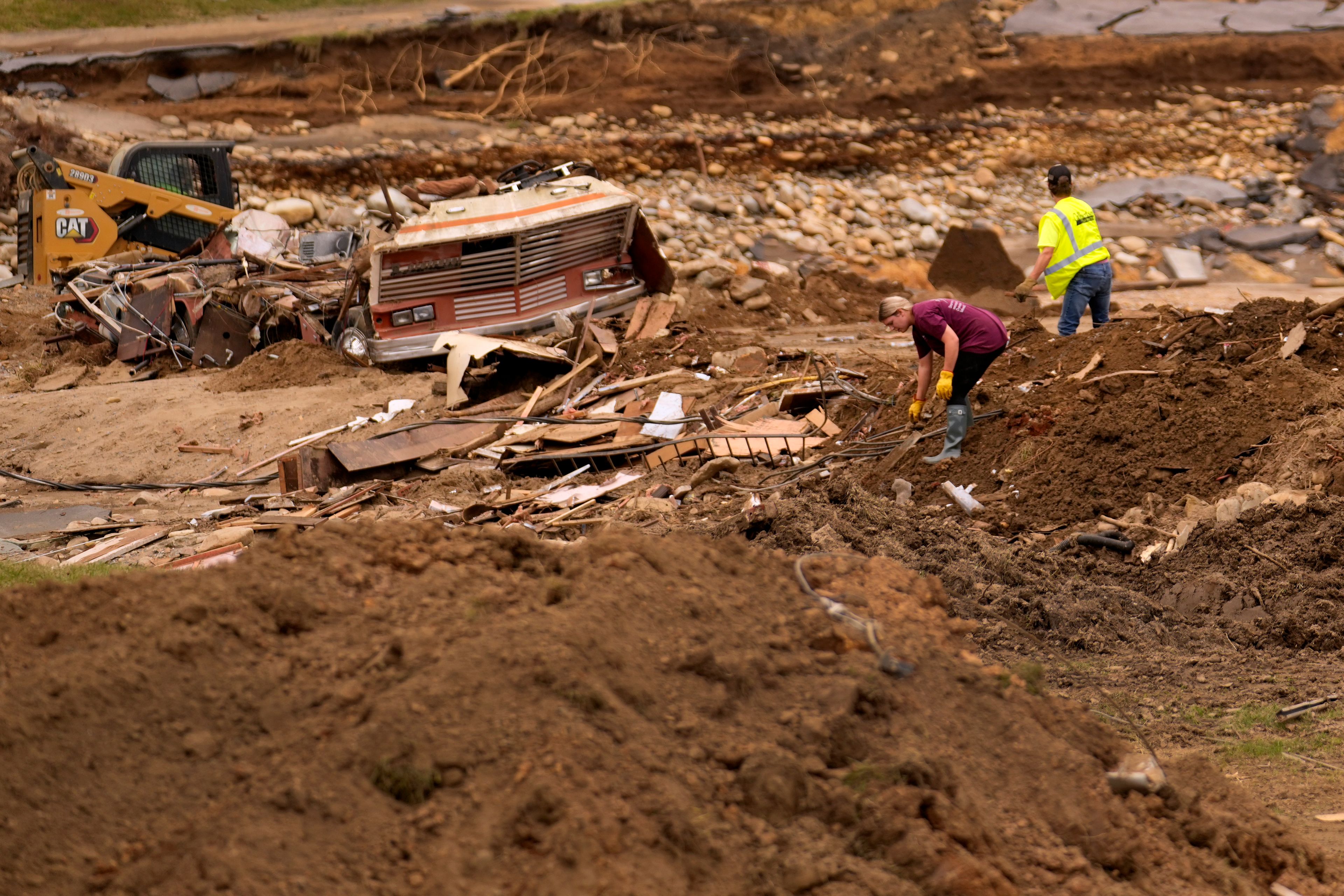 People clean up debris left in the aftermath of Hurricane Helene Friday, Oct. 4, 2024, in Erwin, Tenn. (AP Photo/Jeff Roberson)