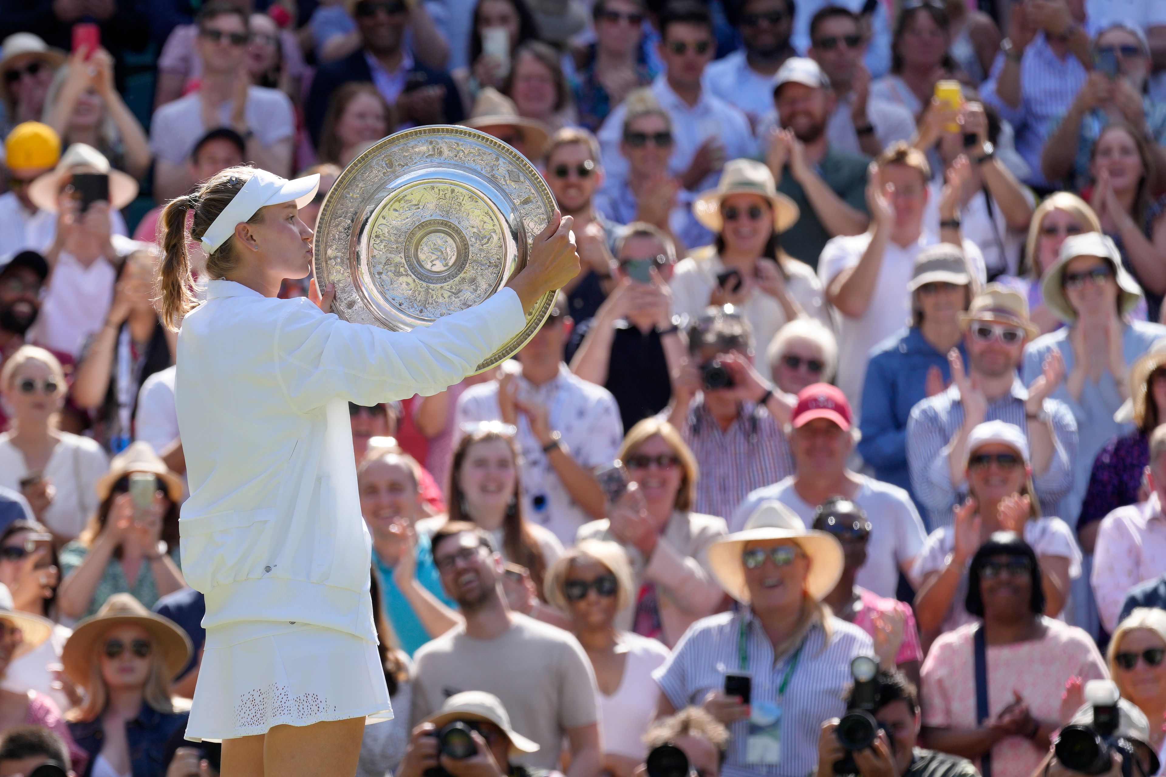 Kazakhstan's Elena Rybakina kisses the trophy as she celebrates after beating Tunisia's Ons Jabeur to win the final of the women's singles on day thirteen of the Wimbledon tennis championships in London, Saturday, July 9, 2022. (AP Photo/Kirsty Wigglesworth)