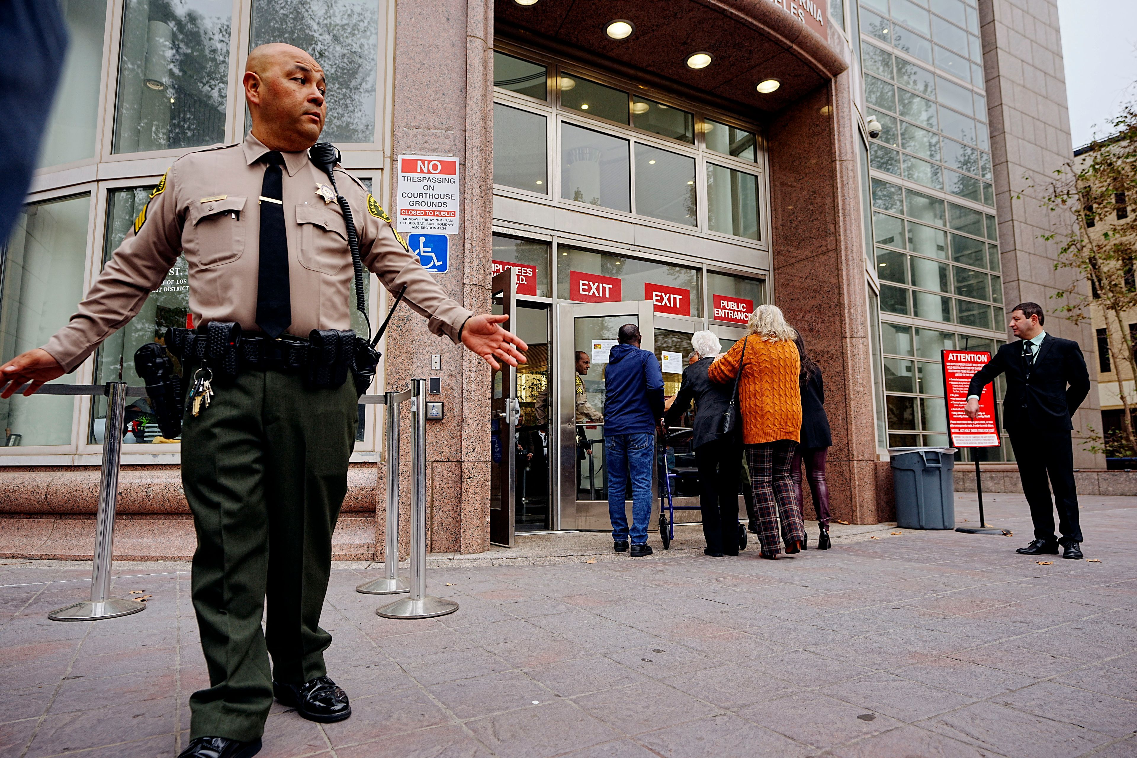 A Los Angeles County sheriff's deputy maintains a perimeter around the Van Nuys courthouse for the hearing for Erik and Lyle Menendez in Los Angeles, Monday, Nov. 25, 2024. (AP Photo/Damian Dovarganes)