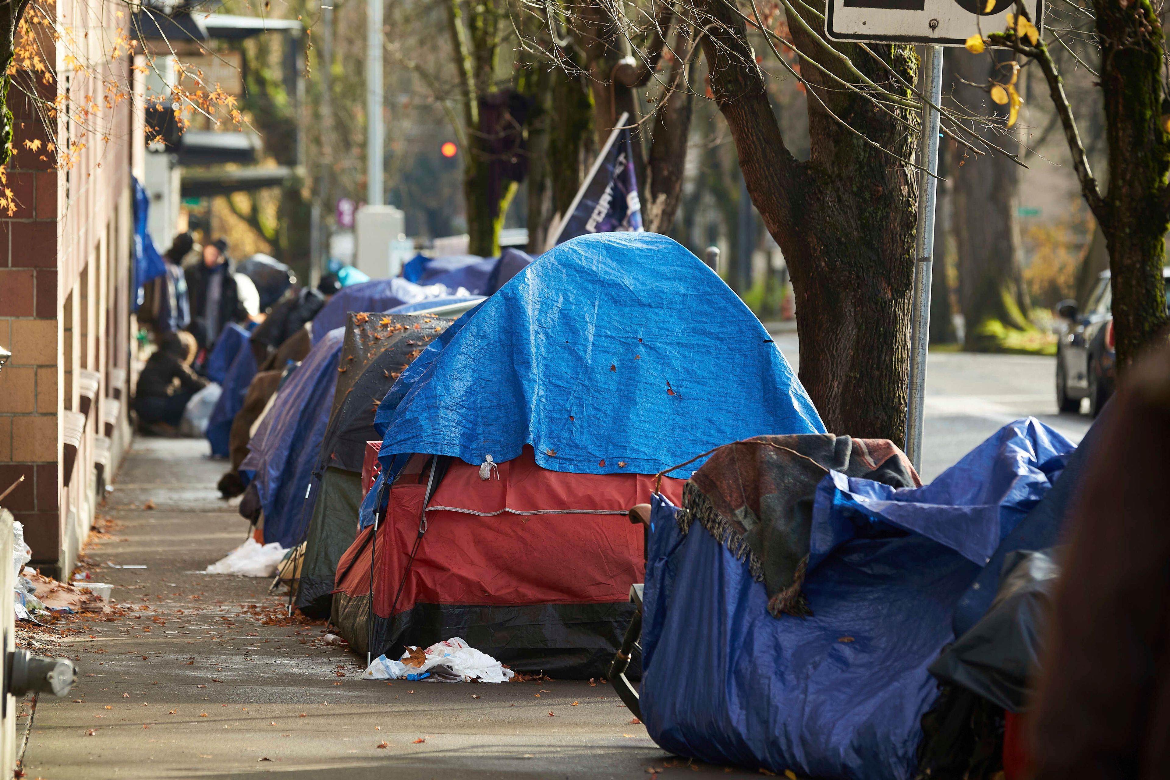 FILE - Tents line the sidewalk on SW Clay Street in Portland, Ore., on Dec. 9, 2020. Oregon lawmakers will take up a full slate of legislation on pressing and polarizing issues from homelessness to gun control to abortion access when the legislative session starts next week after mid-term elections that cost Democrats their supermajority but swept in a new, progressive governor. (AP Photo/Craig Mitchelldyer, File)