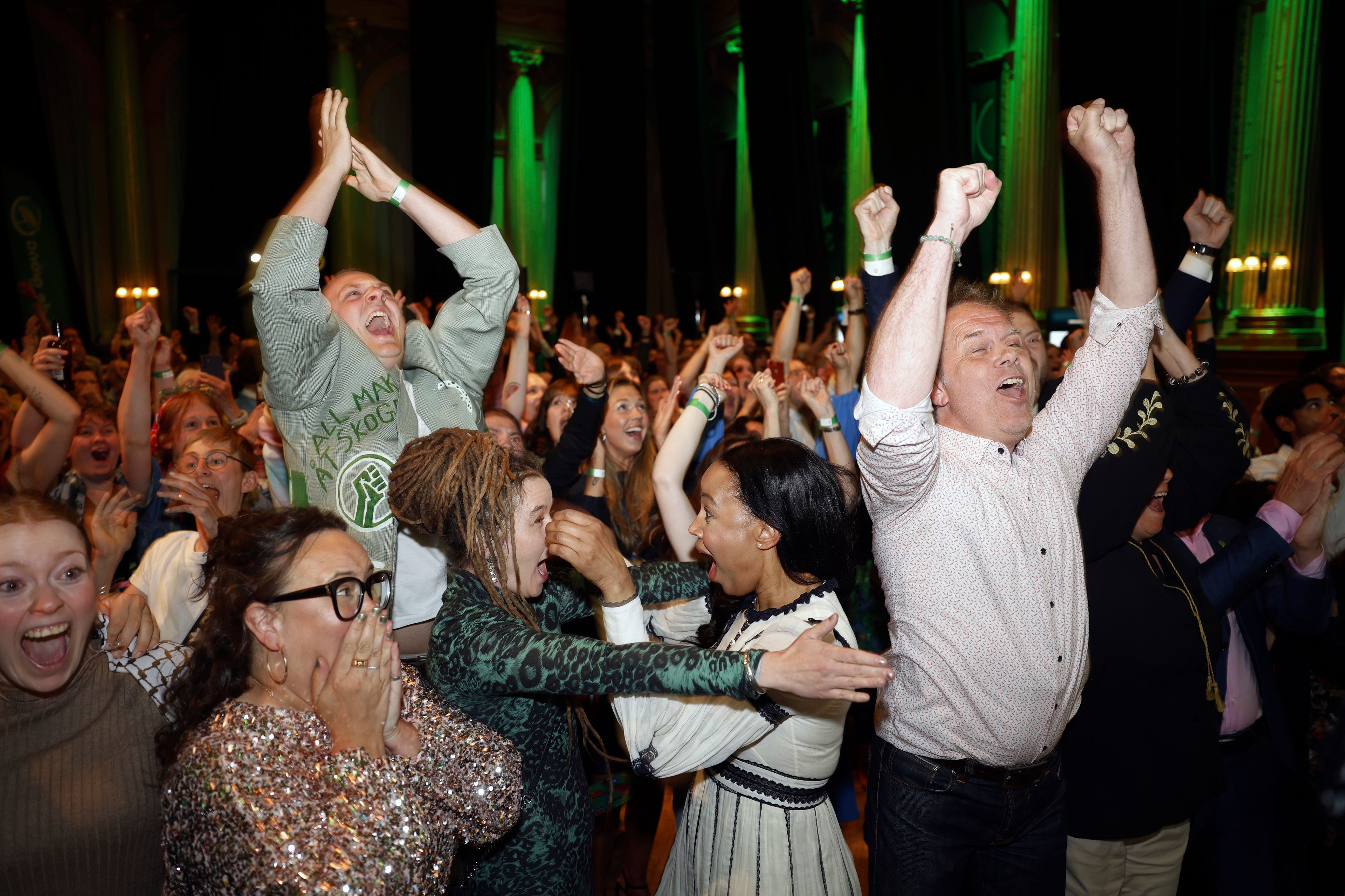 Green Party secretary Katrin Wissing, lower left wearing eyeglasses, spokeswoman Amanda Lind, center left, and top candidates Alice Bah Kuhnke, center right, and Pär Holmgren, right, celebrate with other Green Party members when the results of the polling station survey come in at the Green Party's vigil at Nalen in Stockholm, Sunday, June 9, 2024.