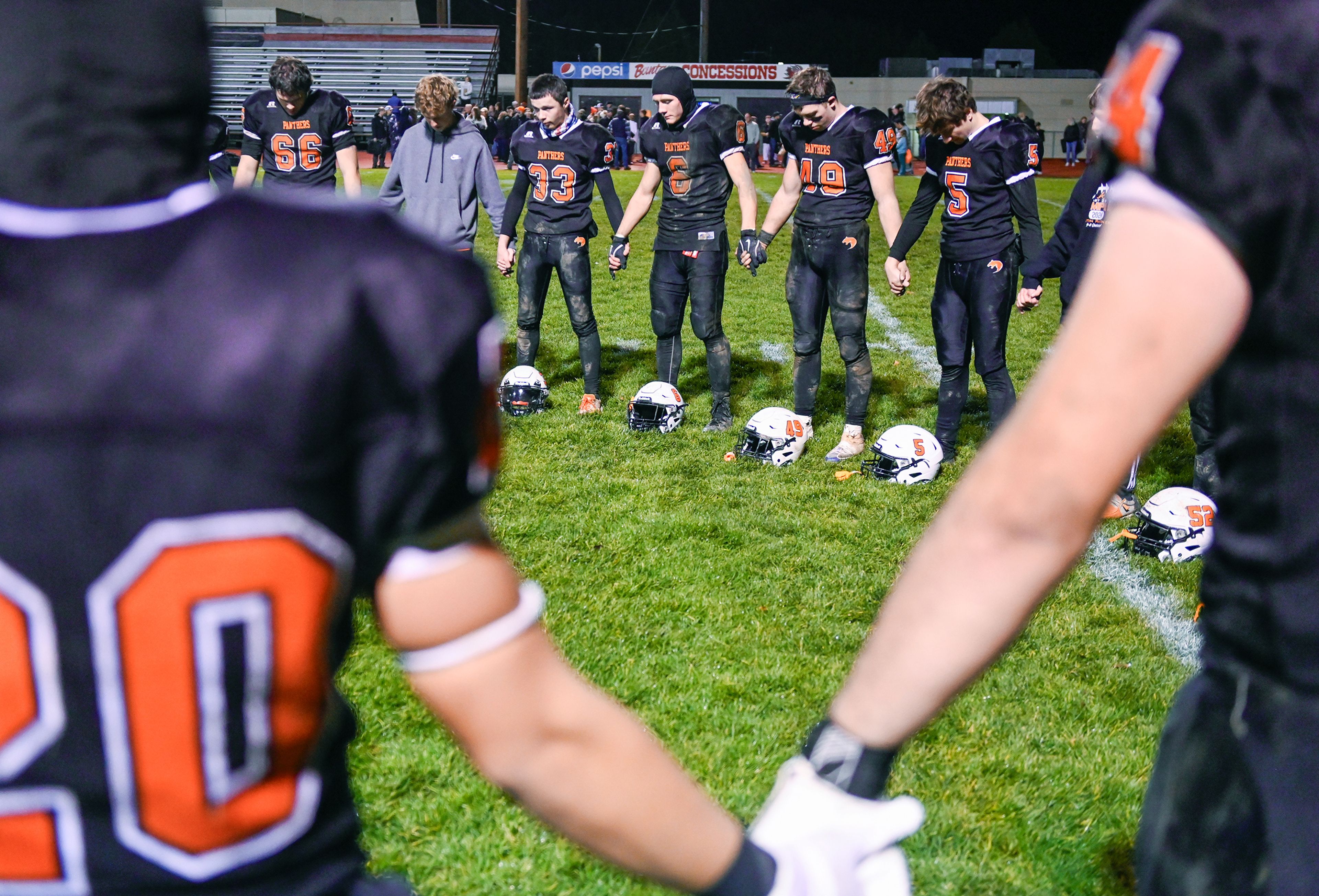 Asotin players join hands and pray after their Washington 2B state tournament win over La Salle Saturday in Clarkston.