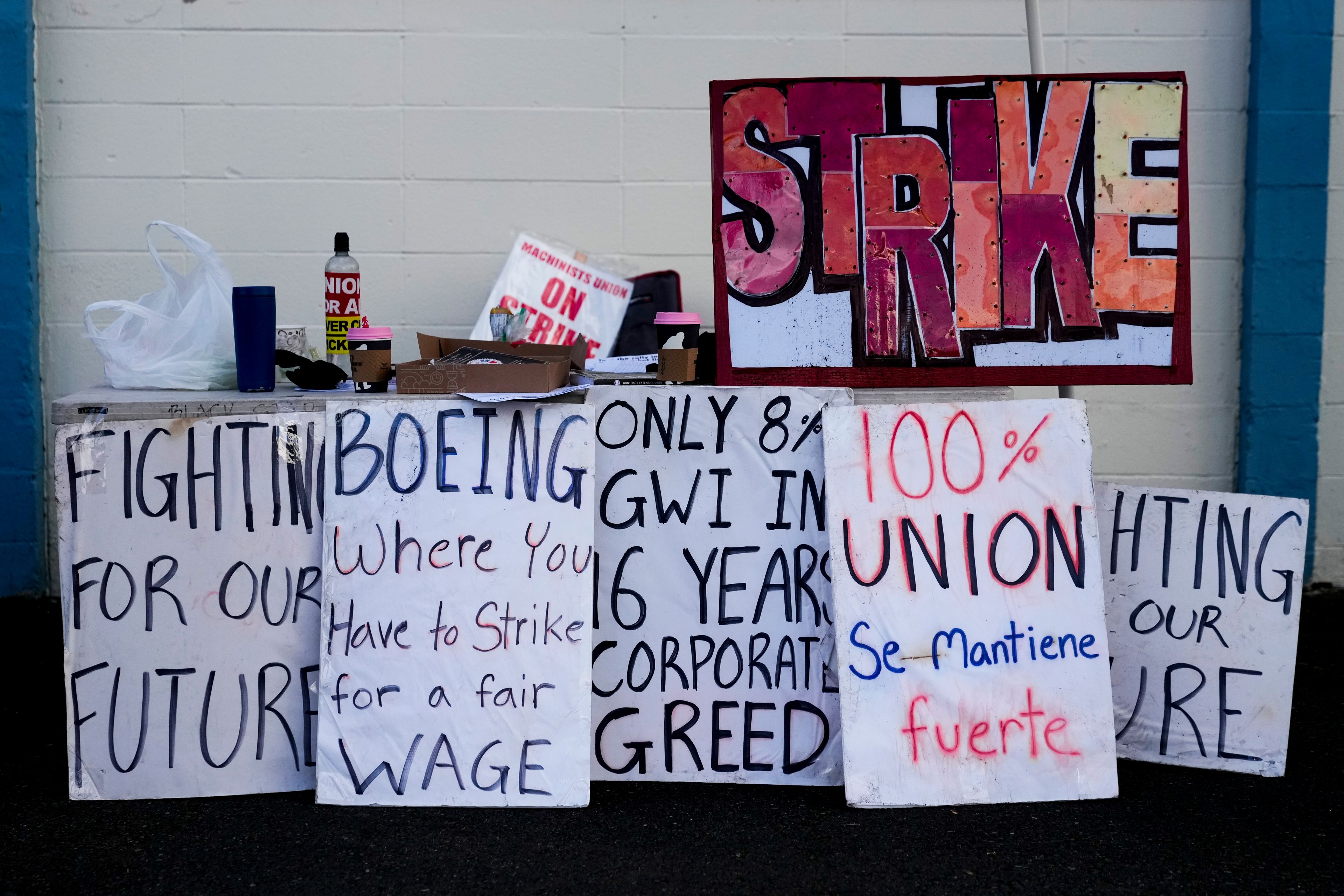 Strike signs line a table outside the Aerospace Machinists Union hall as Boeing employees on strike vote on a new contract offer from the company, Wednesday, Oct. 23, 2024, in Renton, Wash. (AP Photo/Lindsey Wasson)