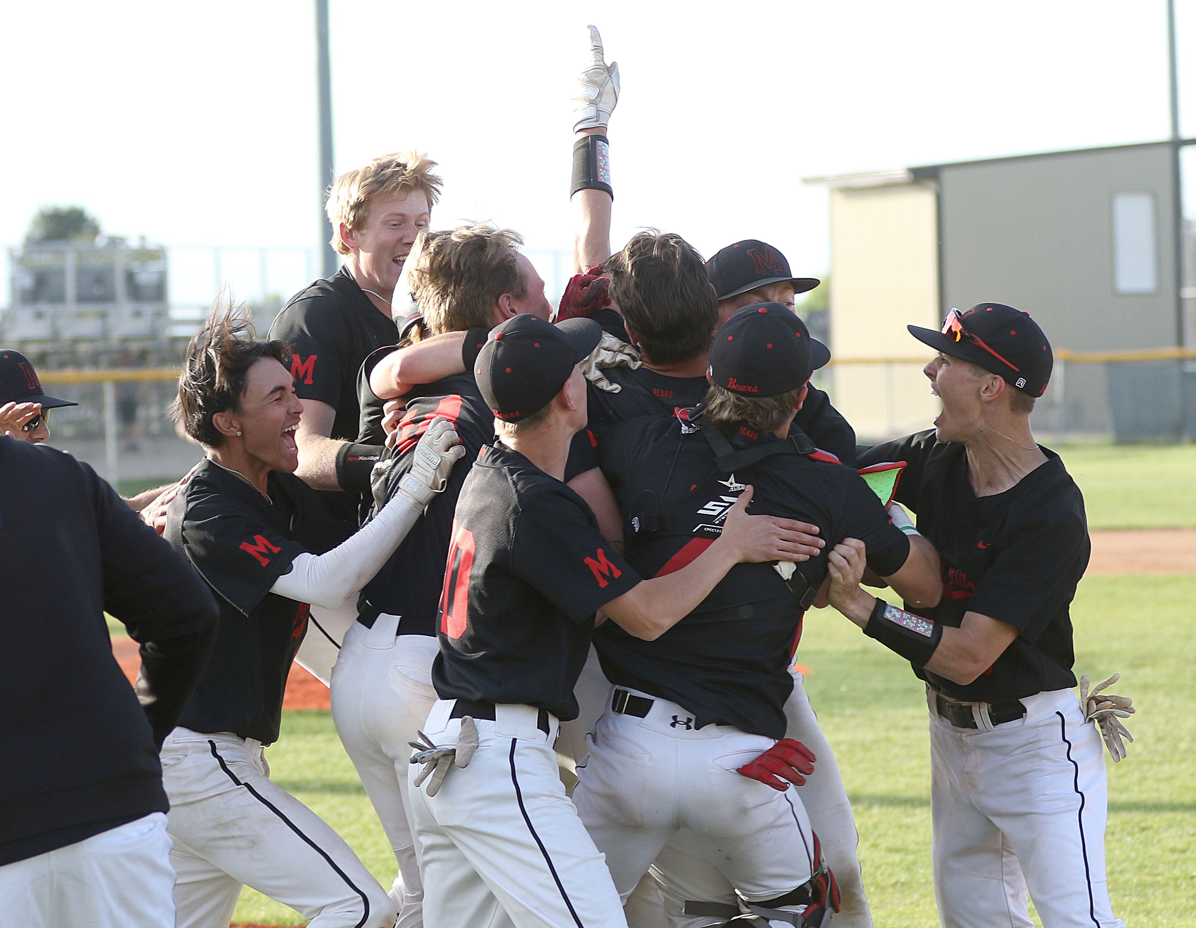 Moscow players swarm Tommy Holt (holding up his finger) after Holt connected for the walk-off hit in the Idaho Class 4A state championship game on Saturday at Vallivue High School in Caldwell, Idaho.