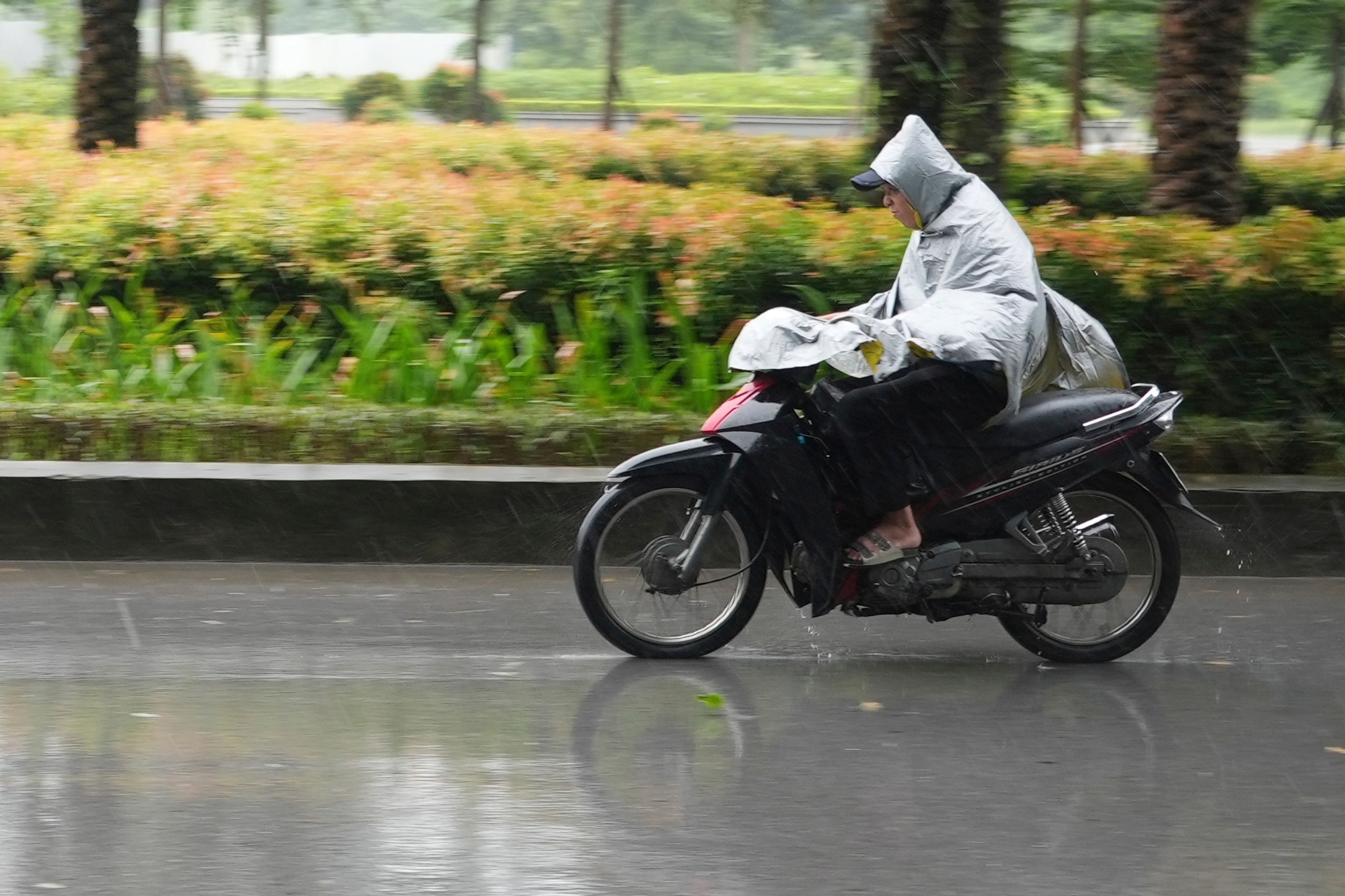 A man rides a motorcycle in the rain caused by typhoon Yagi in Hanoi, Vietnam Saturday, Sept. 7, 2024.