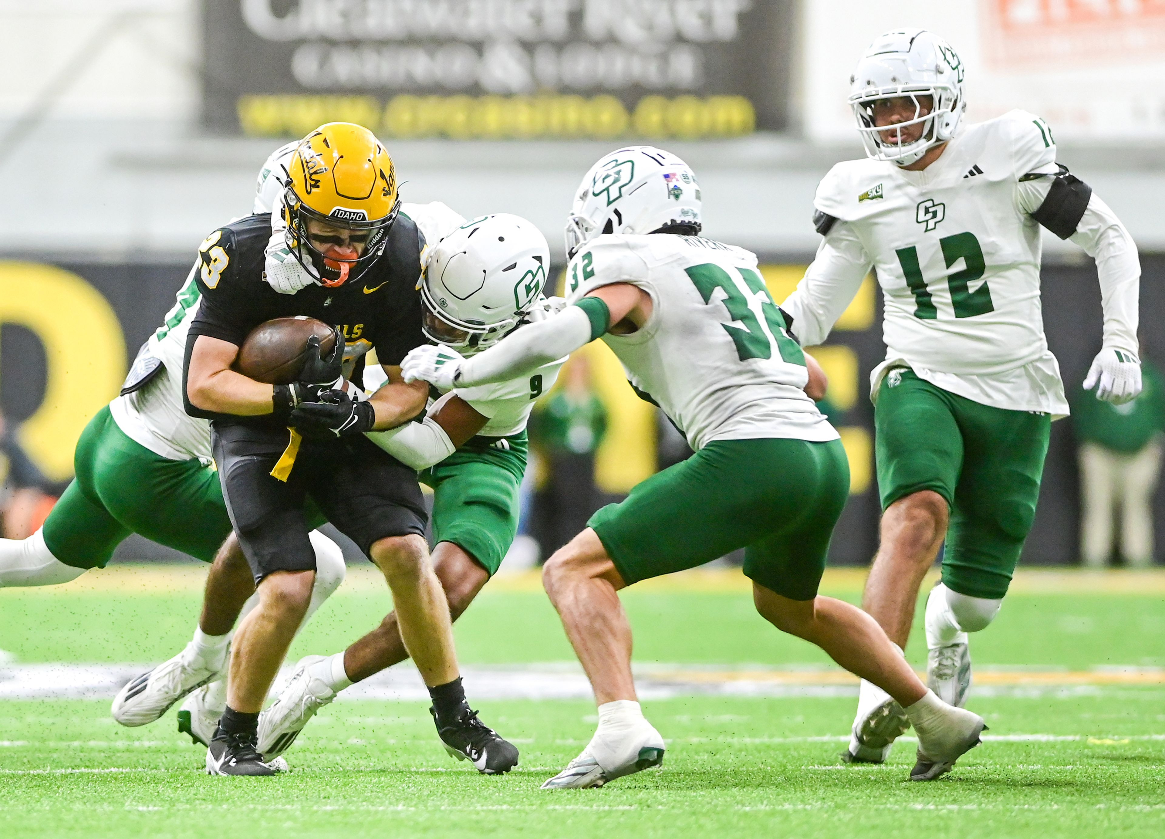 Idaho running back Art Williams is tackled by Cal Poly safety Brian Dukes Jr. as other Cal Poly defenders close in Saturday, Oct. 19, at the P1FCU Kibbie Dome in Moscow.,