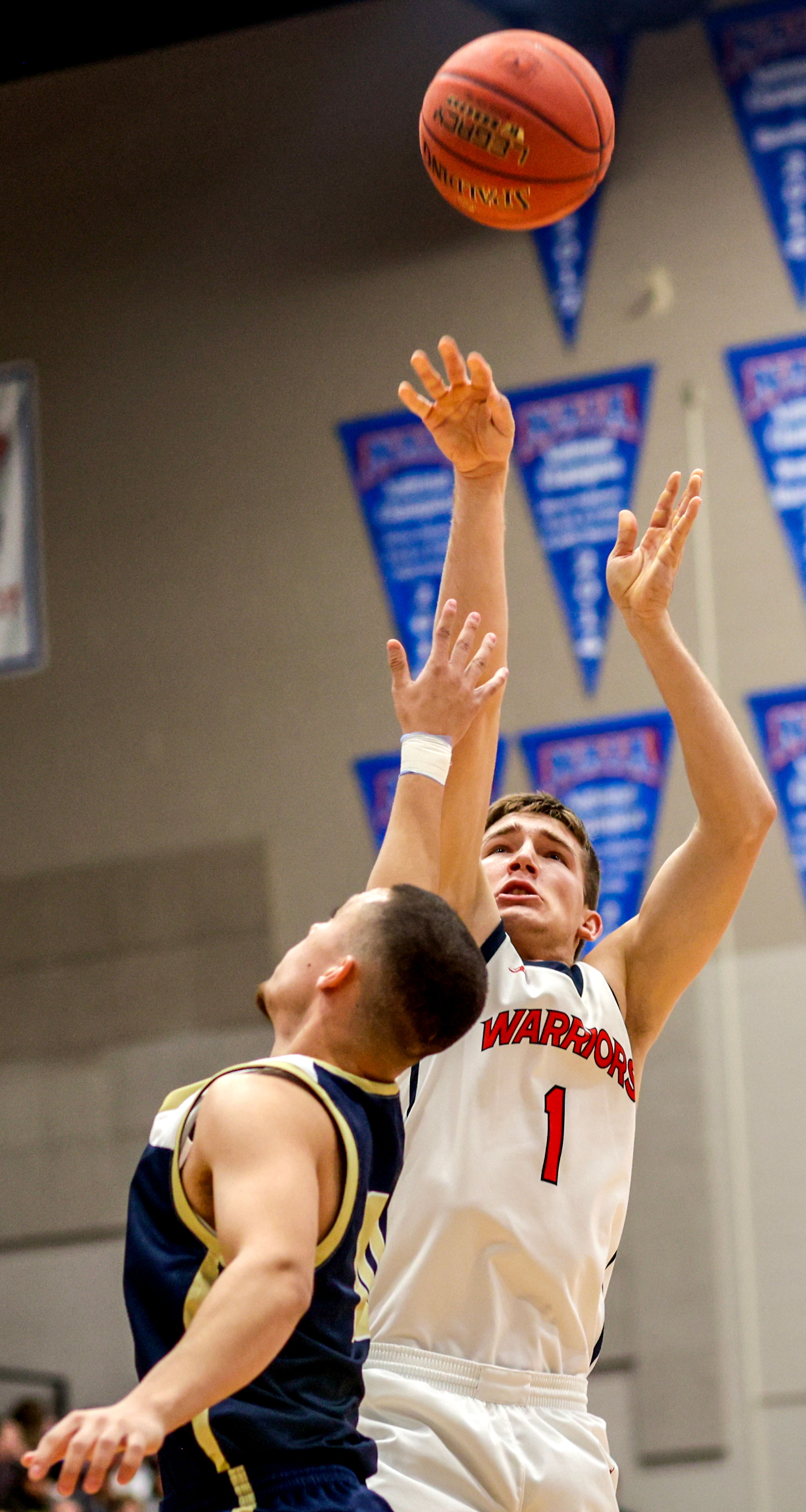 Lewis-Clark State guard John Lustig shoots the ball as Eastern Oregon guard Malachi Afework defends during a Cascade Conference game Friday at Lewis-Clark State College.